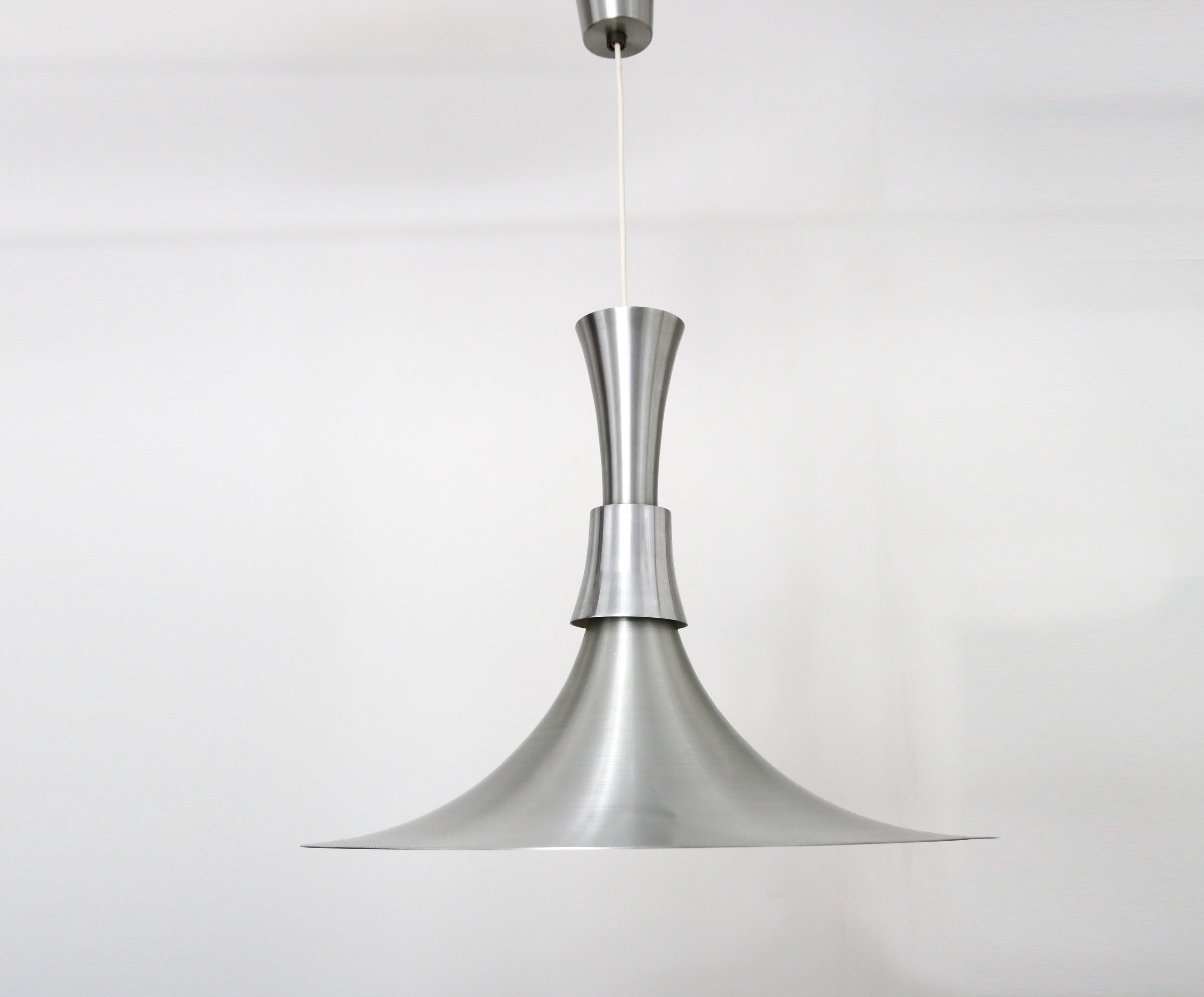 Fabulous Mid Century pendant ceiling light by Bent Nordsted for Lyskaer Belysning

Trumpet shaped ceiling pendant light in spun aluminium, with a wide base and a middle collar of polished aluminium. The original matching ceiling fitting is also