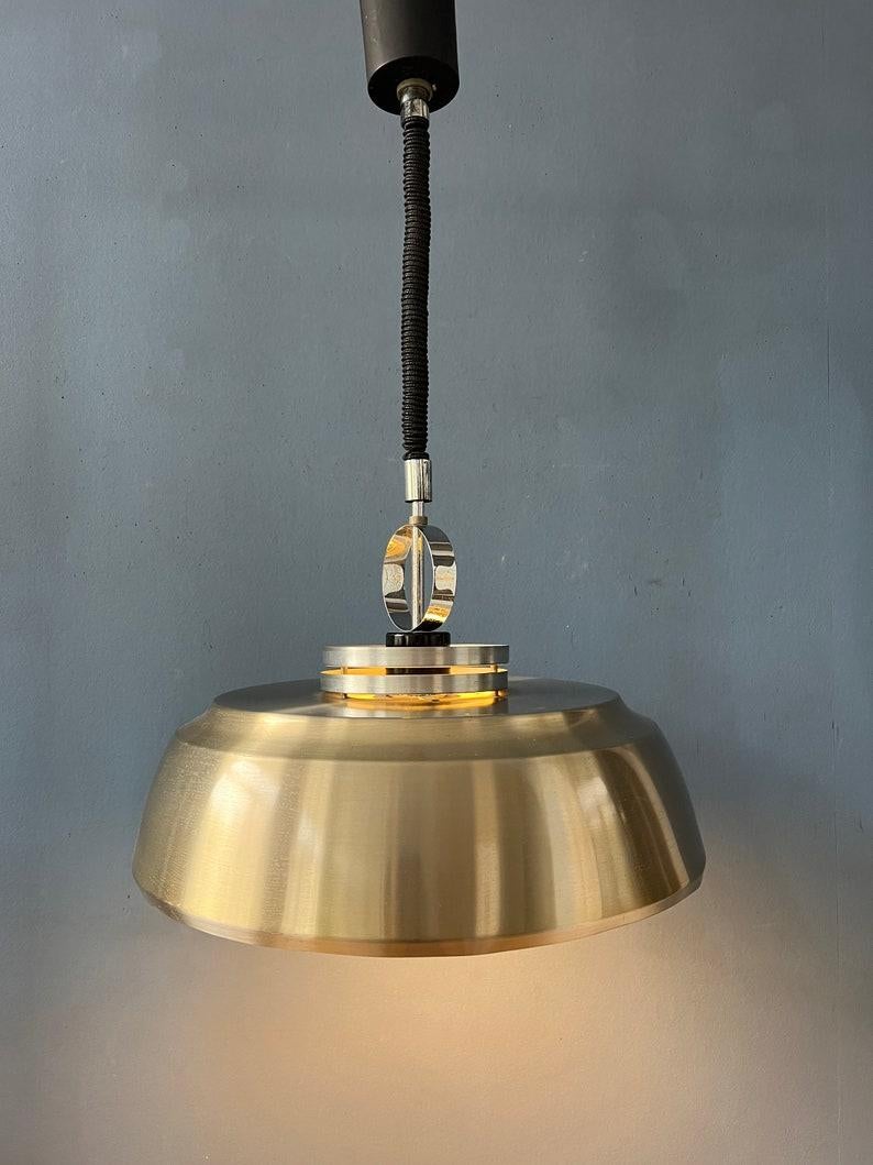 Lampada a sospensione Space Age in argento lucido realizzata in alluminio e cromo. La lampada ha un design semplice ma elegante. La luce si proietta bene attraverso il paralume interno. La lampada richiede una lampadina E27/26