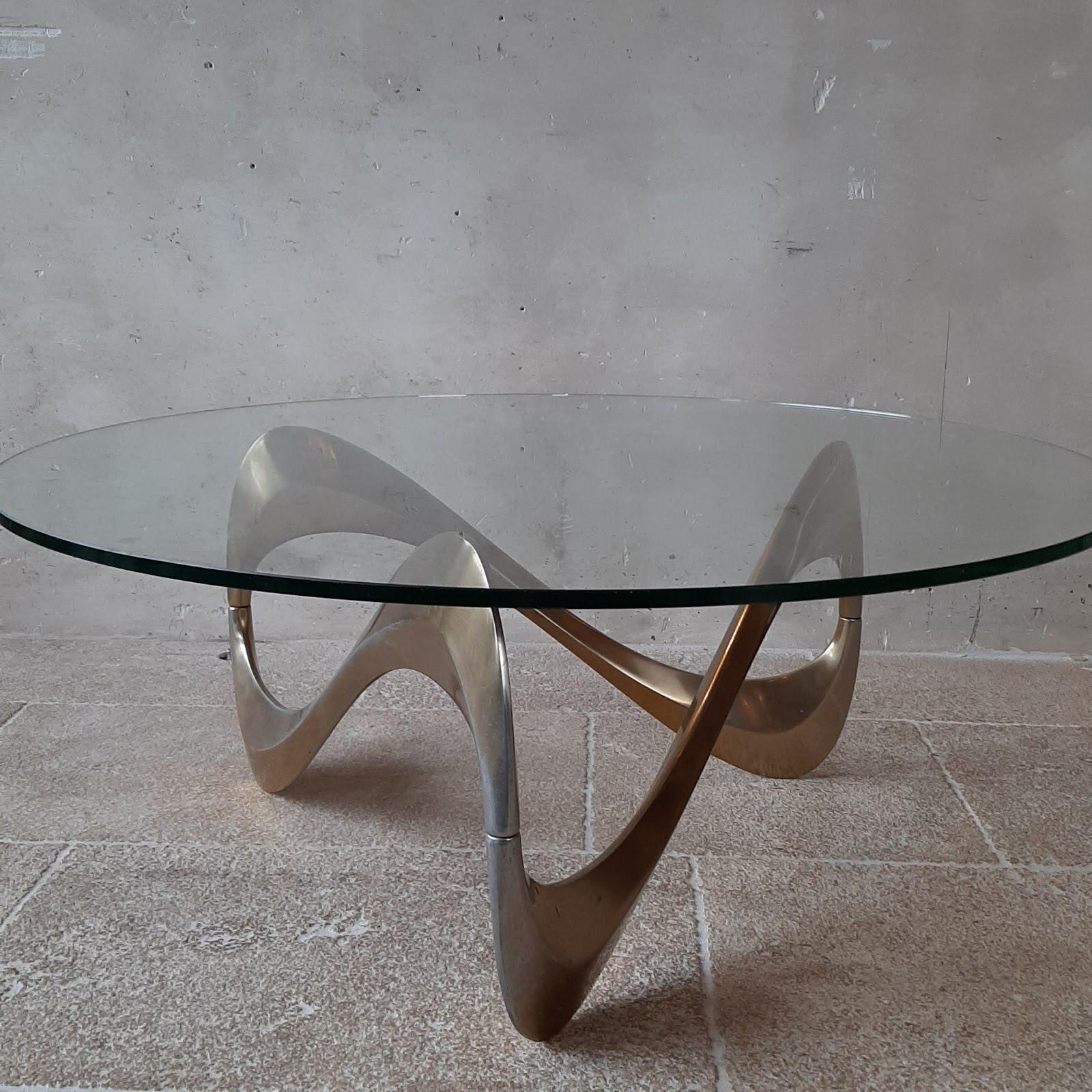 Midcentury coffee table by designer Knut Hesterberg from 1965. The organically shaped 'movement' in the aluminum base is beautifully visible under the large round glass top. This 1960s coffee table is super stylish in interiors such as Mid-Century