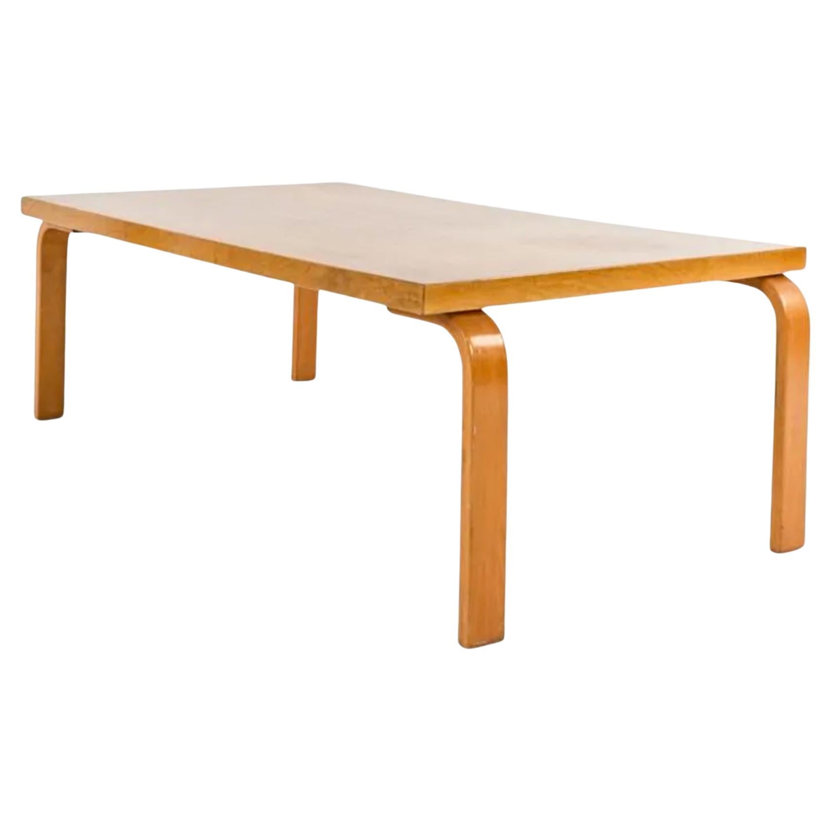 Midcentury coffee or cocktail table or Bench by Finnish architect and designer Alvar Allto. Stands on 4 birch bentwood legs and table top surface rectangle shape all in a blonde finish. Assembled with flat head steel screws. In all original