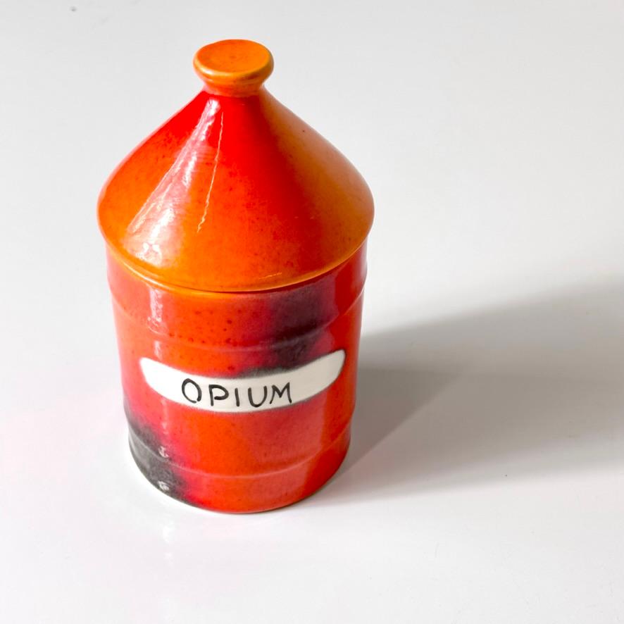 Rare opium Vice Jar by Alvino Bagni for Bitossi
Distributed by Raymor Italy circa 1960s

Lidded apothecary jar glazed in orange and red with burnished details
Signed to underside with original Raymor label

3 inch diameter
6 inch height