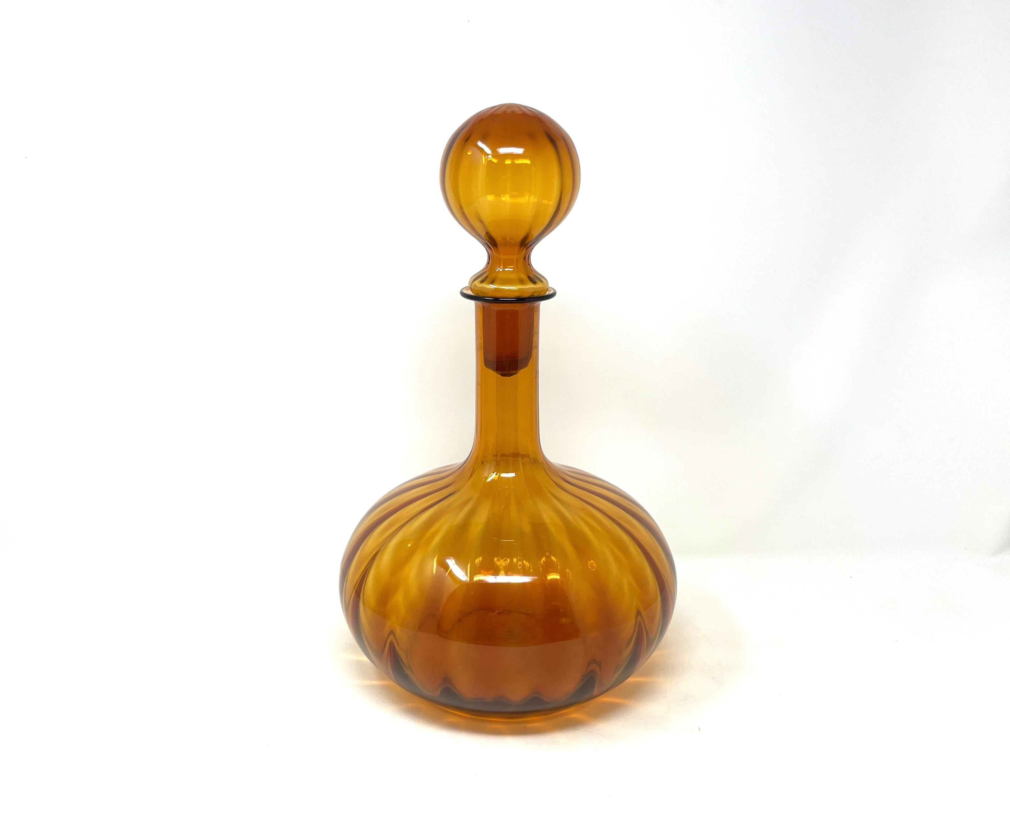 Precioso decantador vintage de vidrio artístico para decoración o función. Precioso tono cálido de ámbar. Sin marcar, pero del estilo de los vidrieros italianos Empoli y Blenko. El tapón original encaja perfectamente. Hay un dibujo estriado vertical