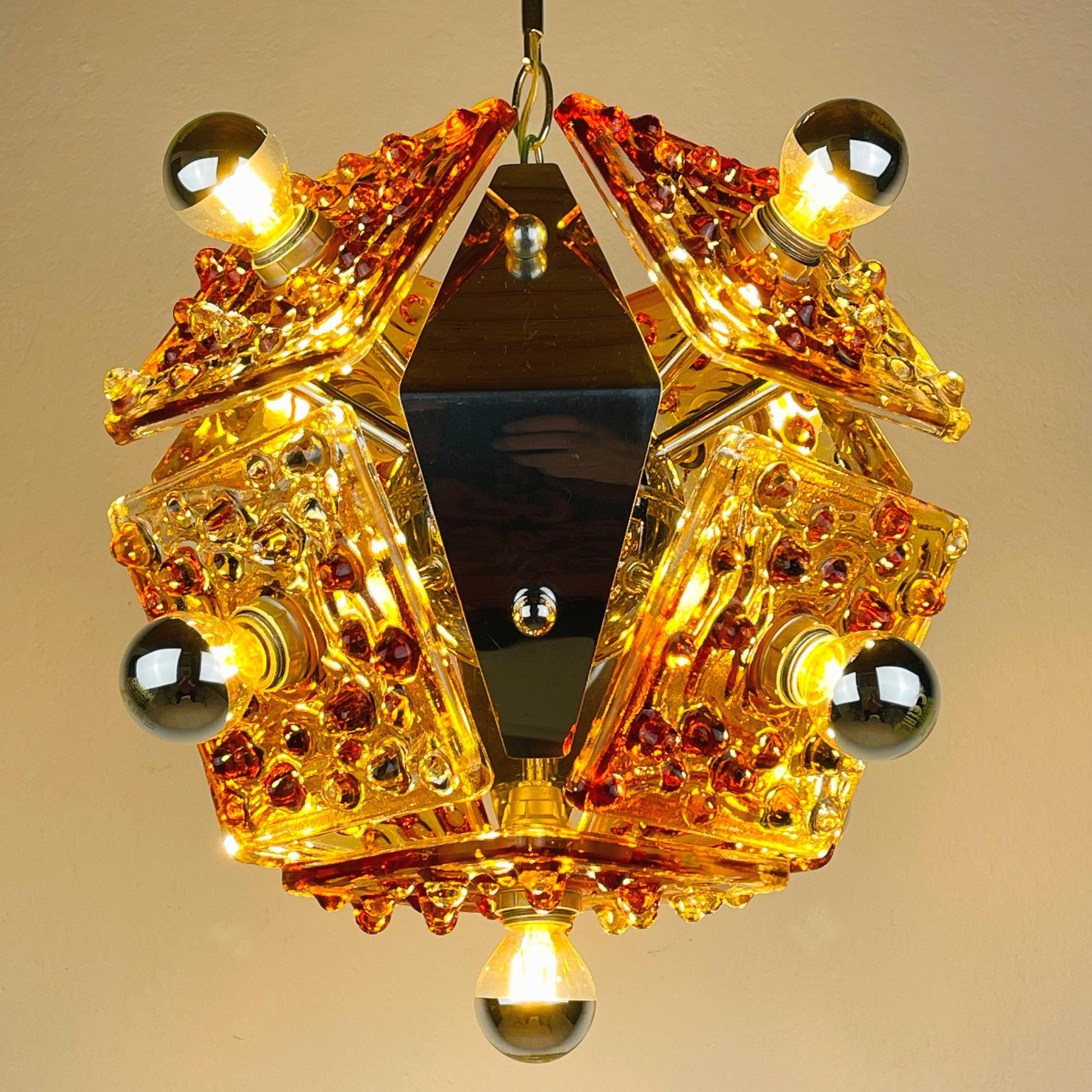 Entrez dans un monde de sophistication intemporelle avec ce lustre Murano ambre du milieu du siècle, une création éblouissante d'AV Mazzega, fabriquée en Italie dans les années 1970. Laissez la lueur chaude de son verre Murano exquis infuser votre