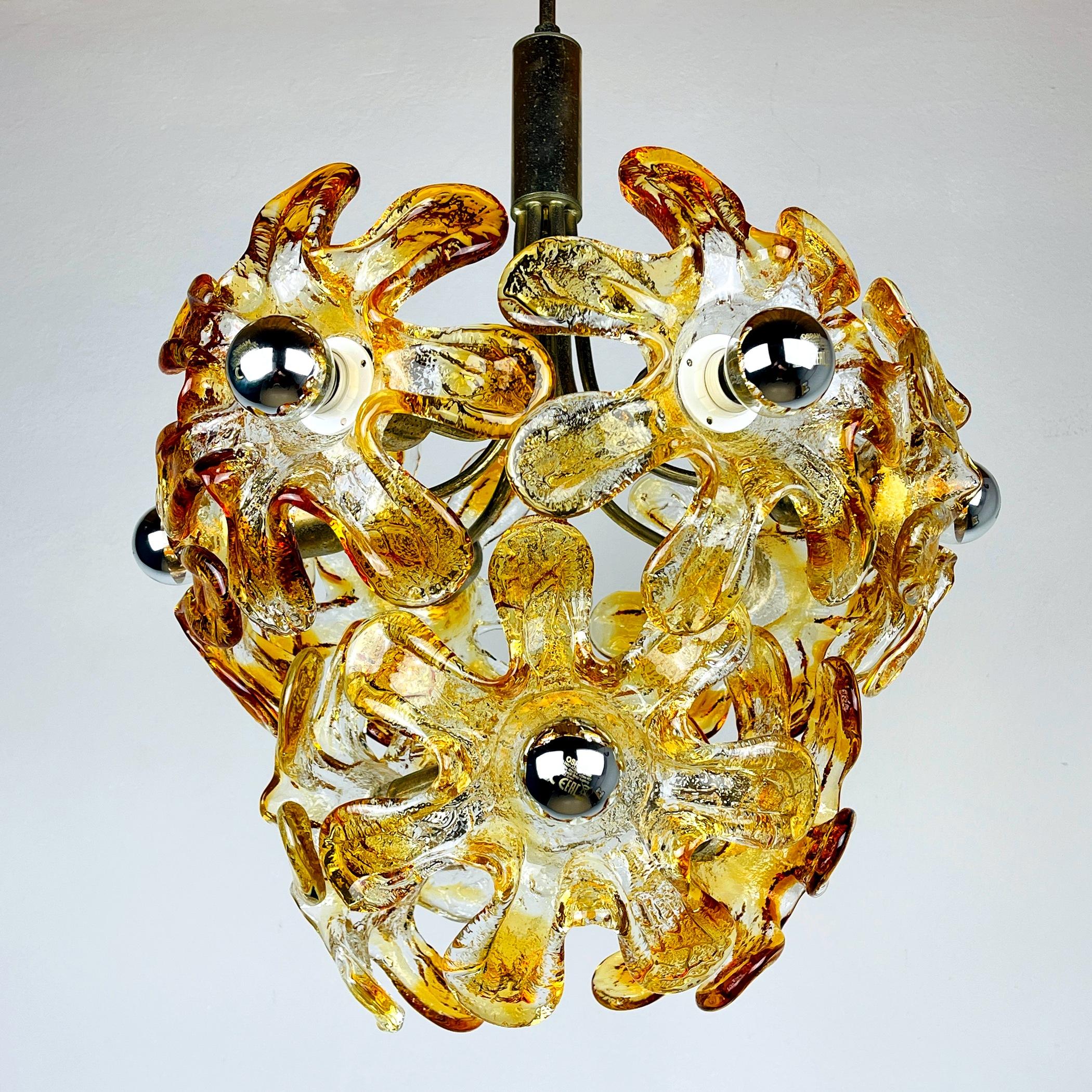Mid-century amber Murano chandelier Flowers Mazzega was made in Italy in the 1970s. AV Mazzega was founded in 1946 by Angelo Vittorio Mazzega. Mazzega and has worked with many internationally renowned designers such as De Lucchi, Piva, Zuccheri over