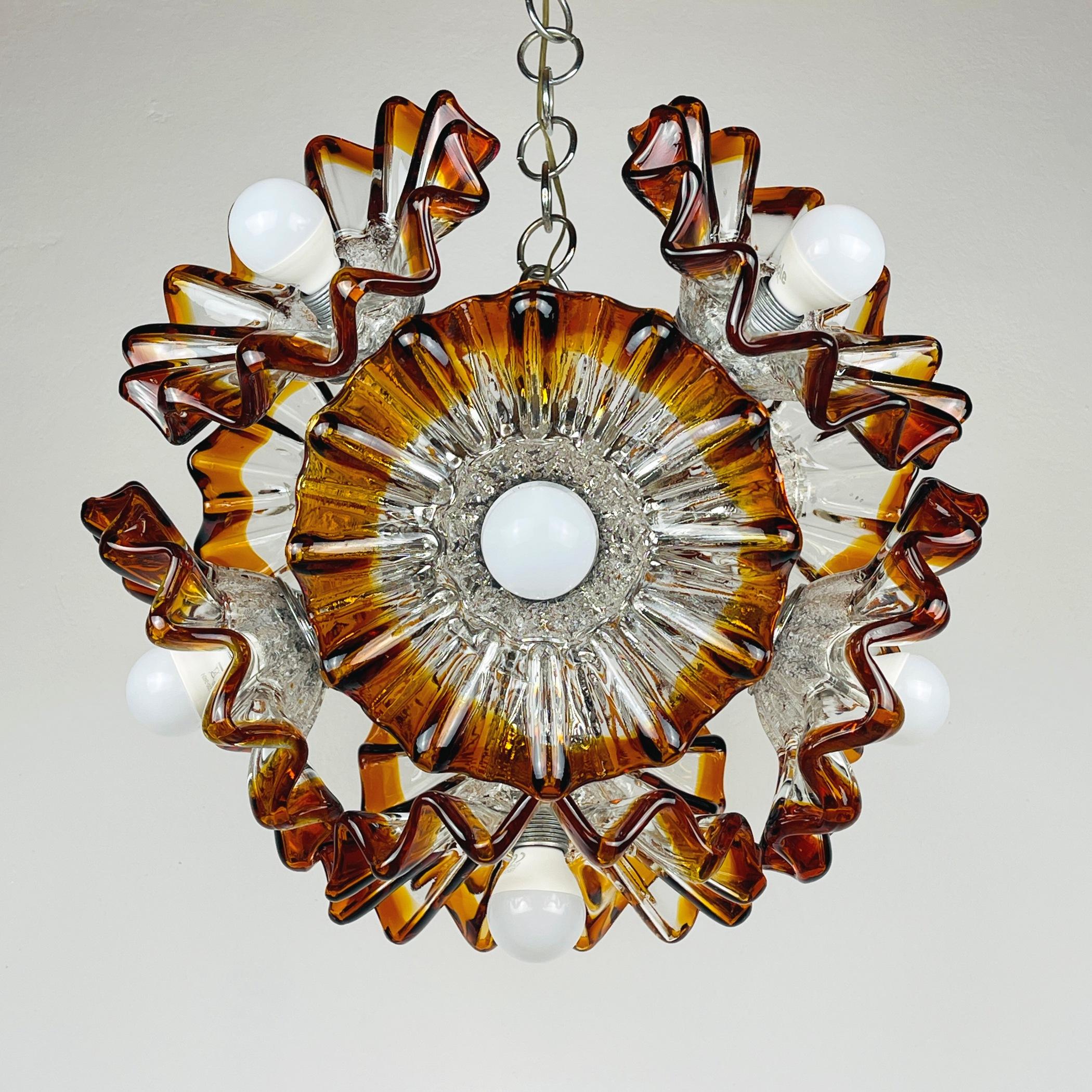 Add a touch of mid-century elegance to your space with this exquisite amber Murano chandelier Sputnik by AVMazzega. Crafted in Italy during the 1970s, this piece showcases the timeless beauty of Murano glass. AV Mazzega, founded by Angelo Vittorio