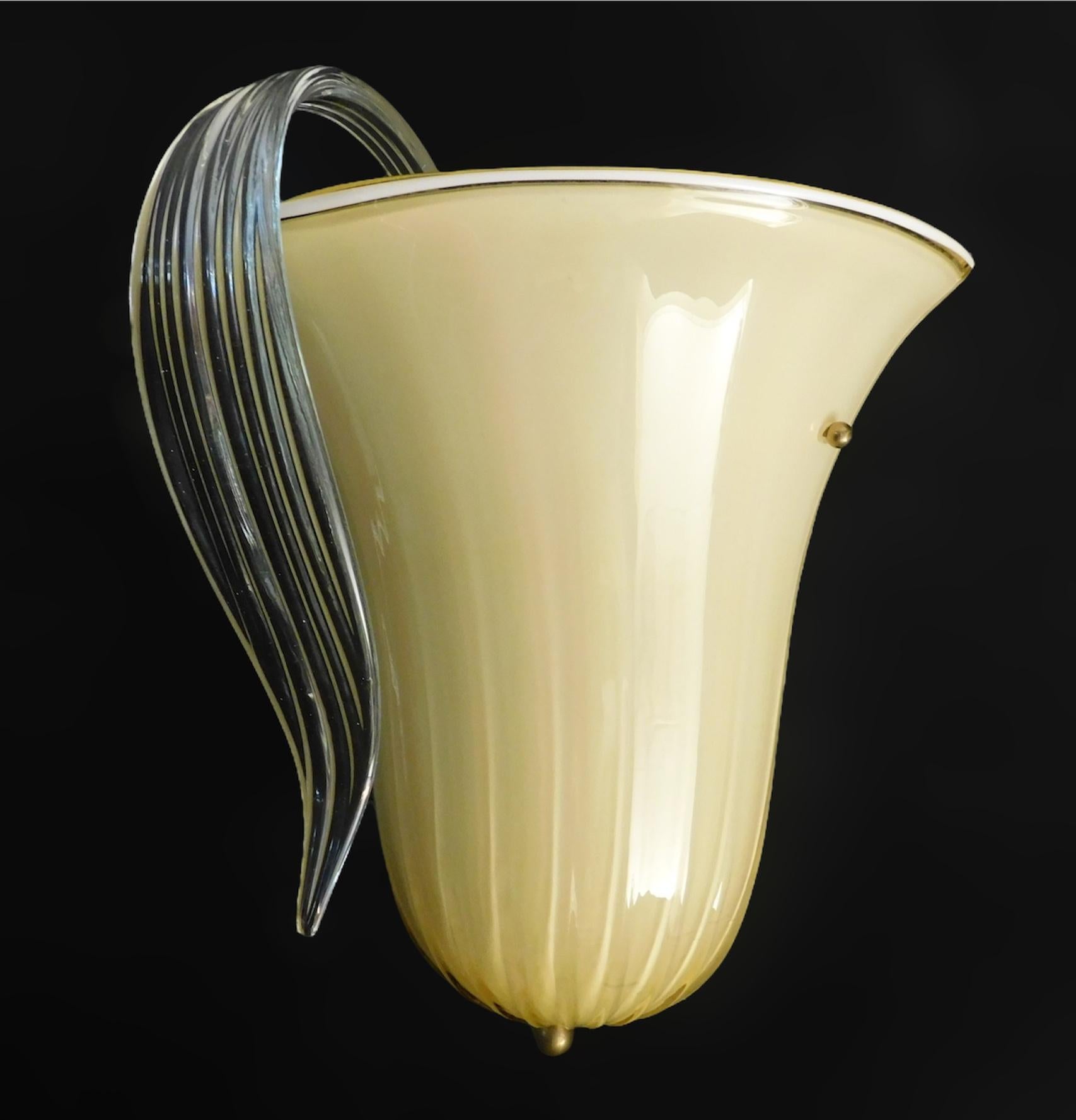 Applique d'epoca italiana con paralume in vetro di Murano ambrato incamiciato e una foglia in vetro trasparente rigato montata su una struttura in ottone / Made in Italy, circa 1960
Misure: altezza 13,5 pollici, larghezza 12,5 pollici, profondità 9