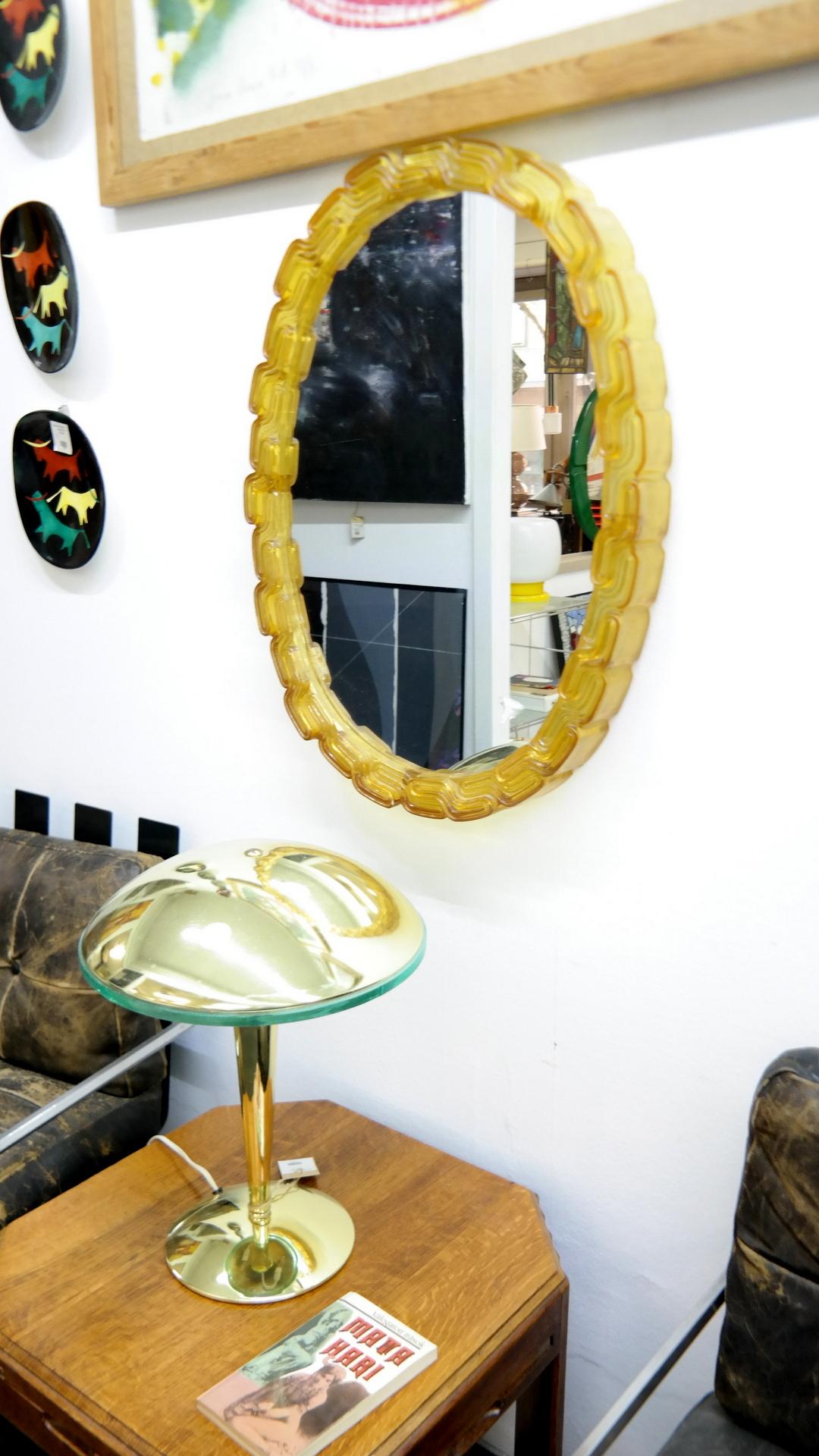Cast plastic midcentury amber oval mirror.