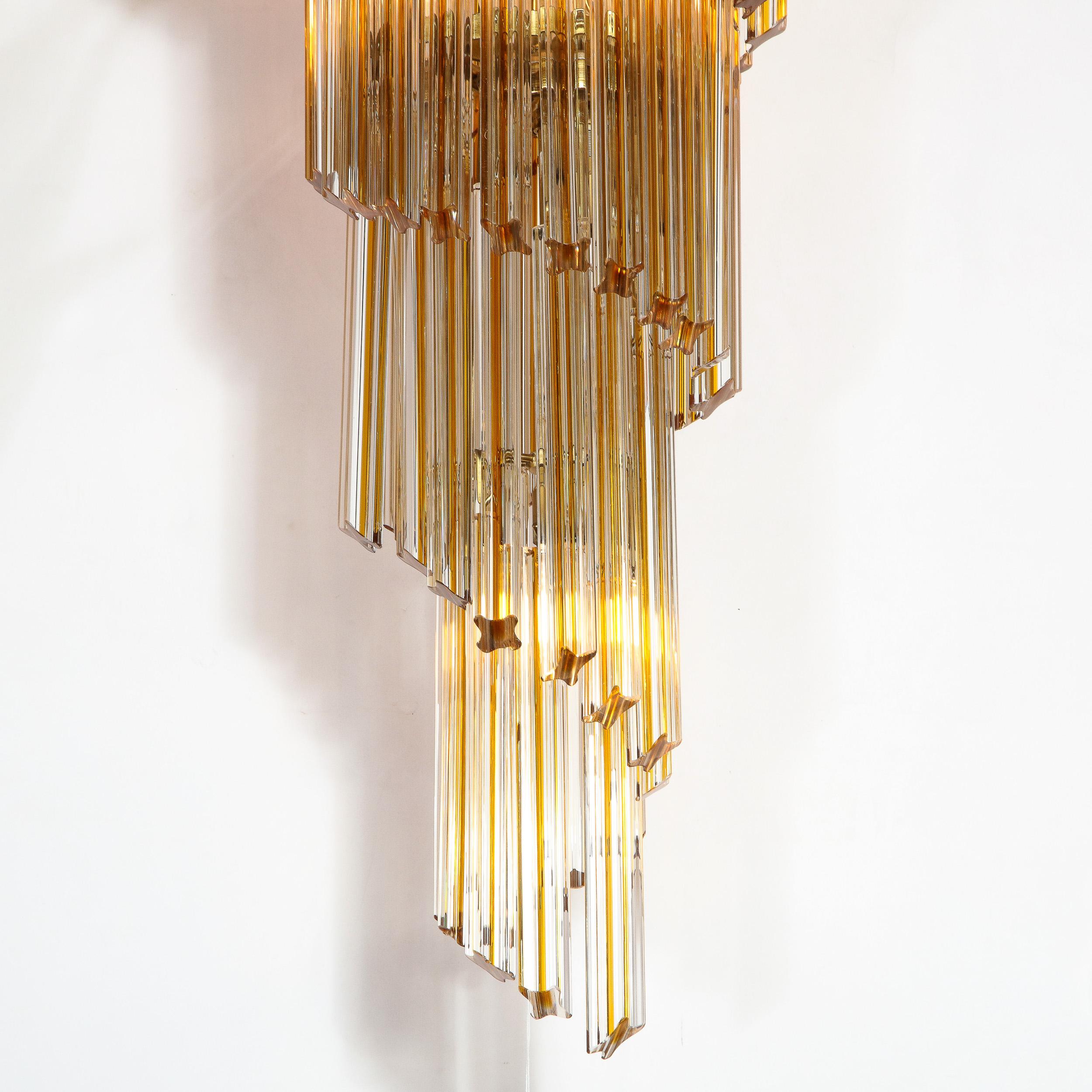 This stunning Mid-Century Modern camer chandelier was realized in Italy circa 1970. It features a spiral helix form composed of five tiers of amber hued quadretti crystals that taper downwards with brass fittings throughout. The piece is imbued with