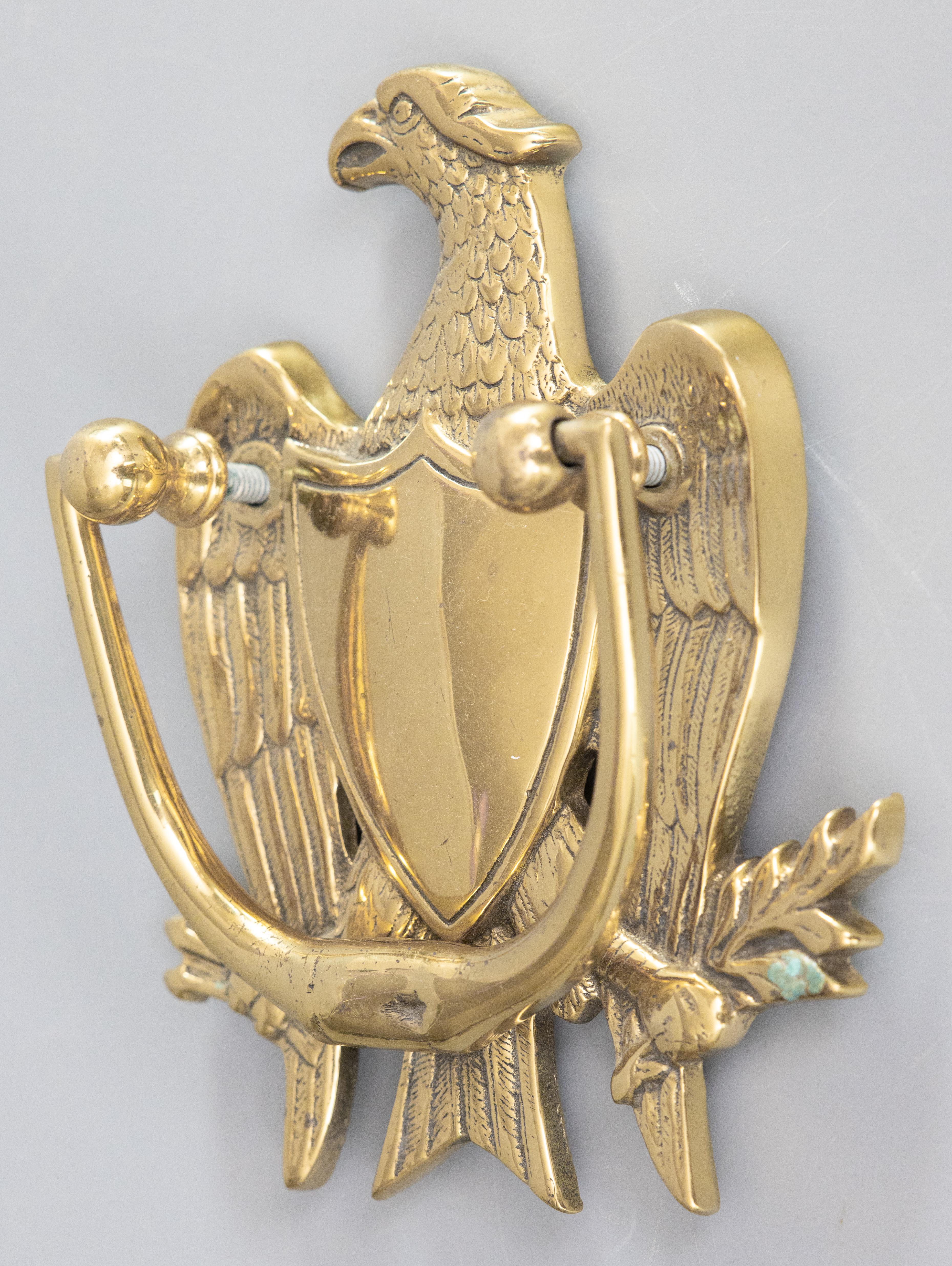 Un bel battente d'epoca in ottone con aquila di Feder, circa 1950. Questo battiporta regale è ben fuso e pesante, con un peso di circa 2 libbre, a forma di aquila maestosa con uno scudo centrale in una bella patina di ottone. Sarebbe un meraviglioso