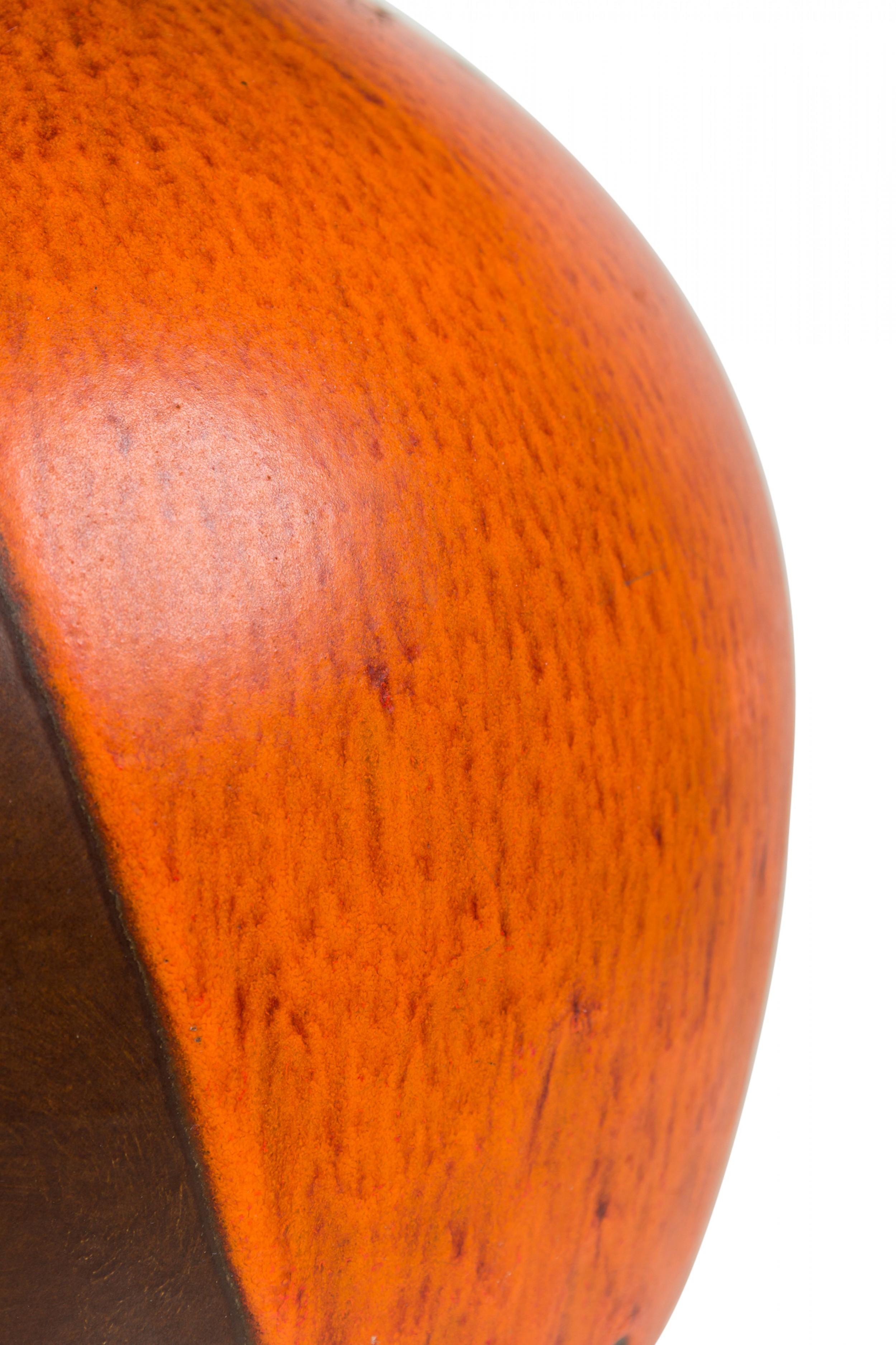 Lampe de table américaine du milieu du siècle en céramique de forme globulaire se rétrécissant vers le haut, abritant une tige en laiton avec une prise d'interrupteur fonctionnant et une harpe. Le glaçage en gouttes de lave orange enveloppe tout le