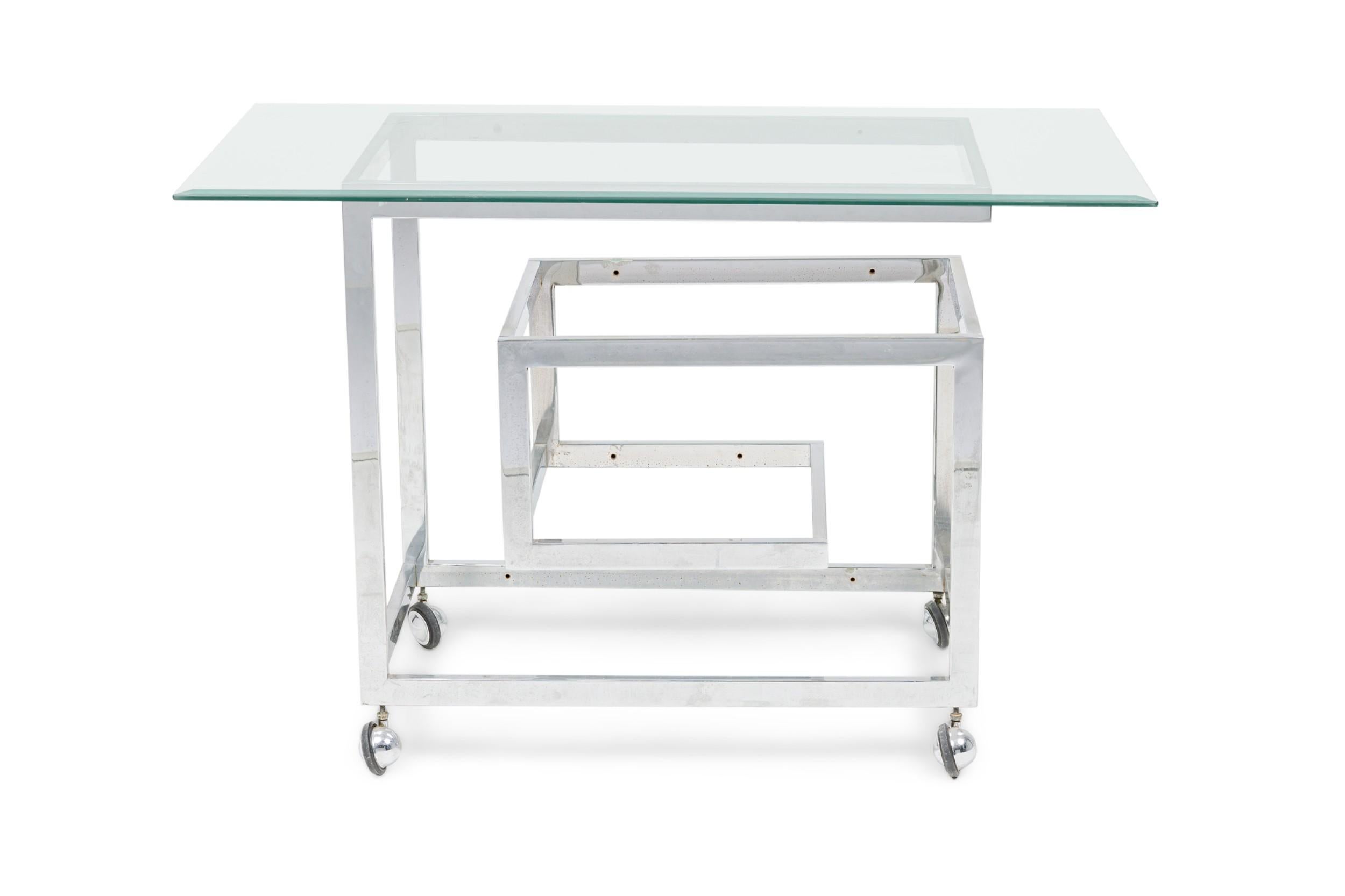 Mid-Century American Modern chrome bar cart with cantilevered shelves for fitted glass, inspired by the classic Greek keyfret pattern, resting on four casters. (In the style of MILO BAUGHMAN)

Missing piece of glass on shelf