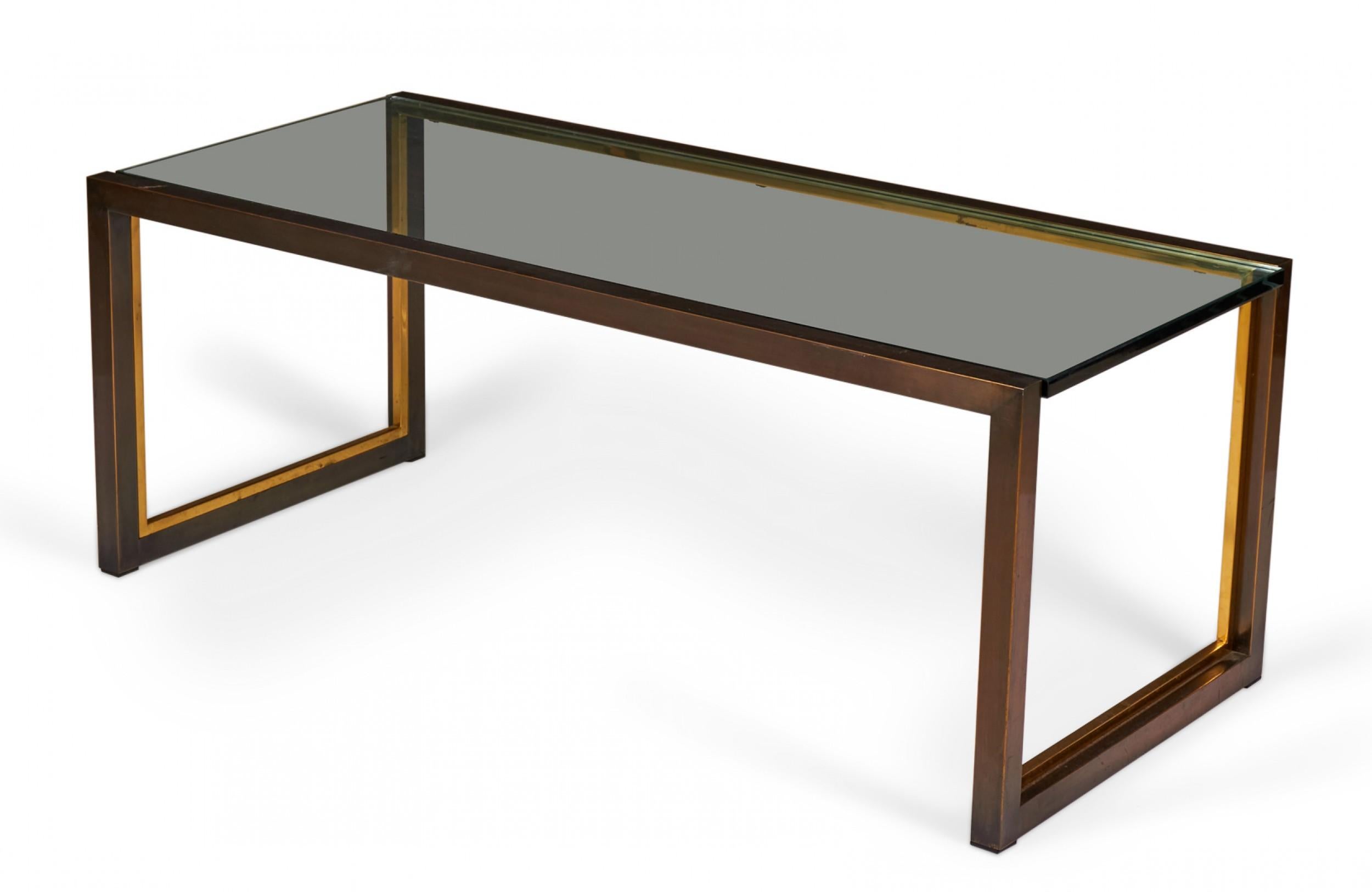 American Mid-Century rectangular coffee / cocktail table with a copper-colored metal bracket-shaped base with bronze trim and an inset smoked glass top.

Condition: Good; Wear consistent with age and use