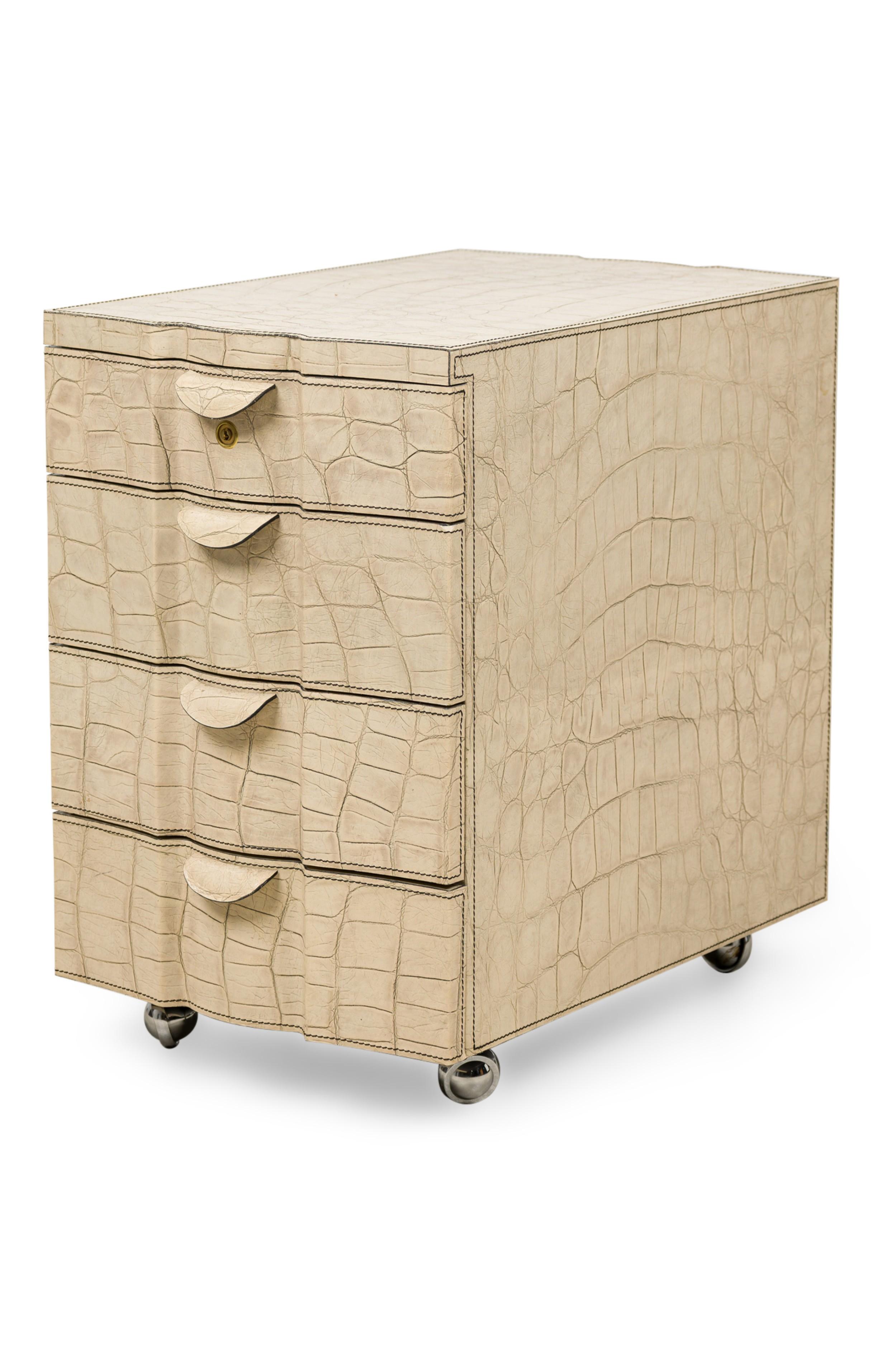 Mid-Century American rectangular shaped chest embossed in off-white faux reptile leather featuring 4 narrow pullout drawers with petal form pulls and circular brass keyhole all with magnetic hinges and removable interior compartments, resting on 4