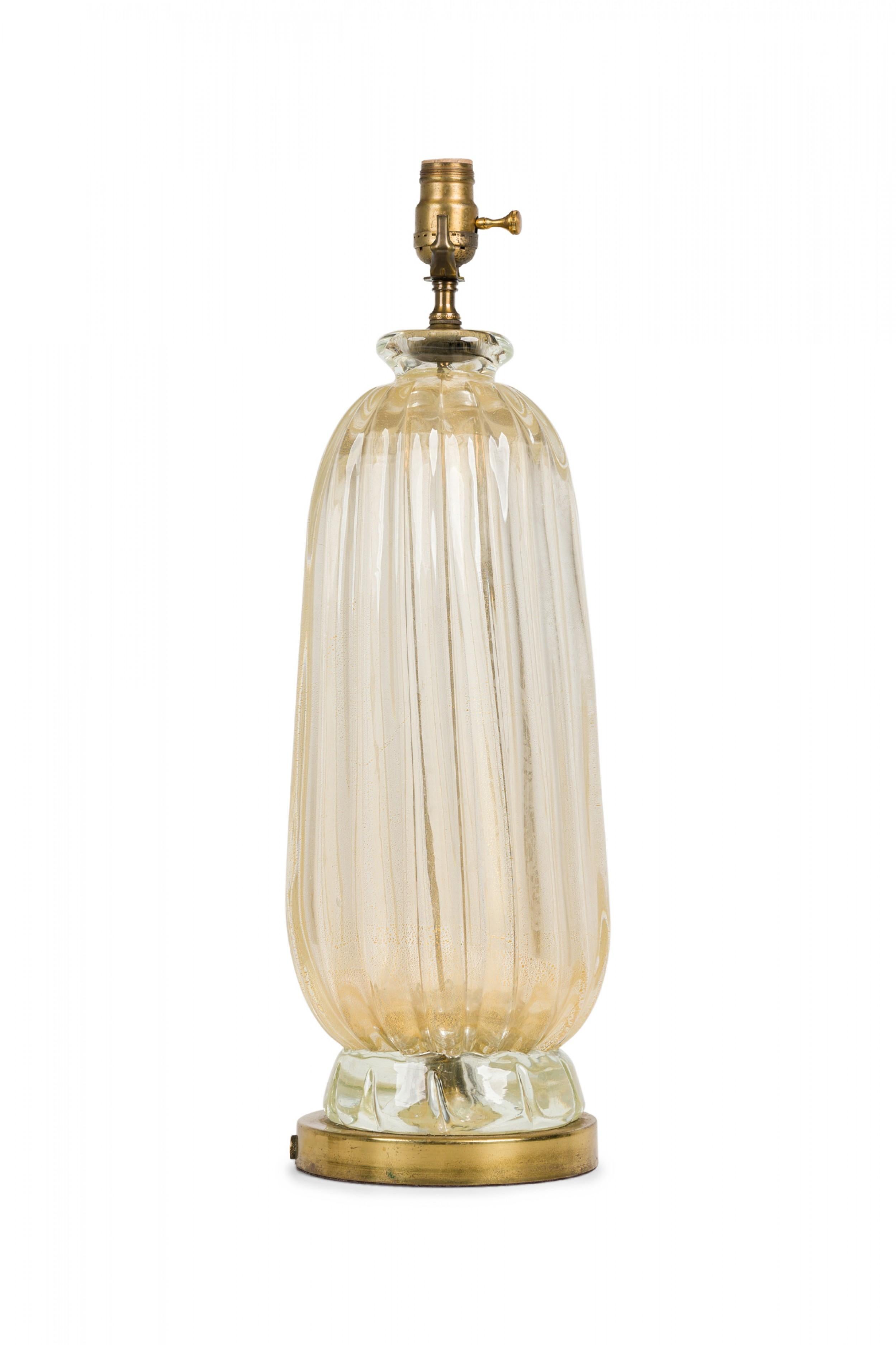 Midcentury American glass table lamp in lobed tapered ovoid form with a waisted pinched neck and extended functioning brass light switch socket, resting on a tapered bottom foot, mounted on a gilt metal flattened circular base.