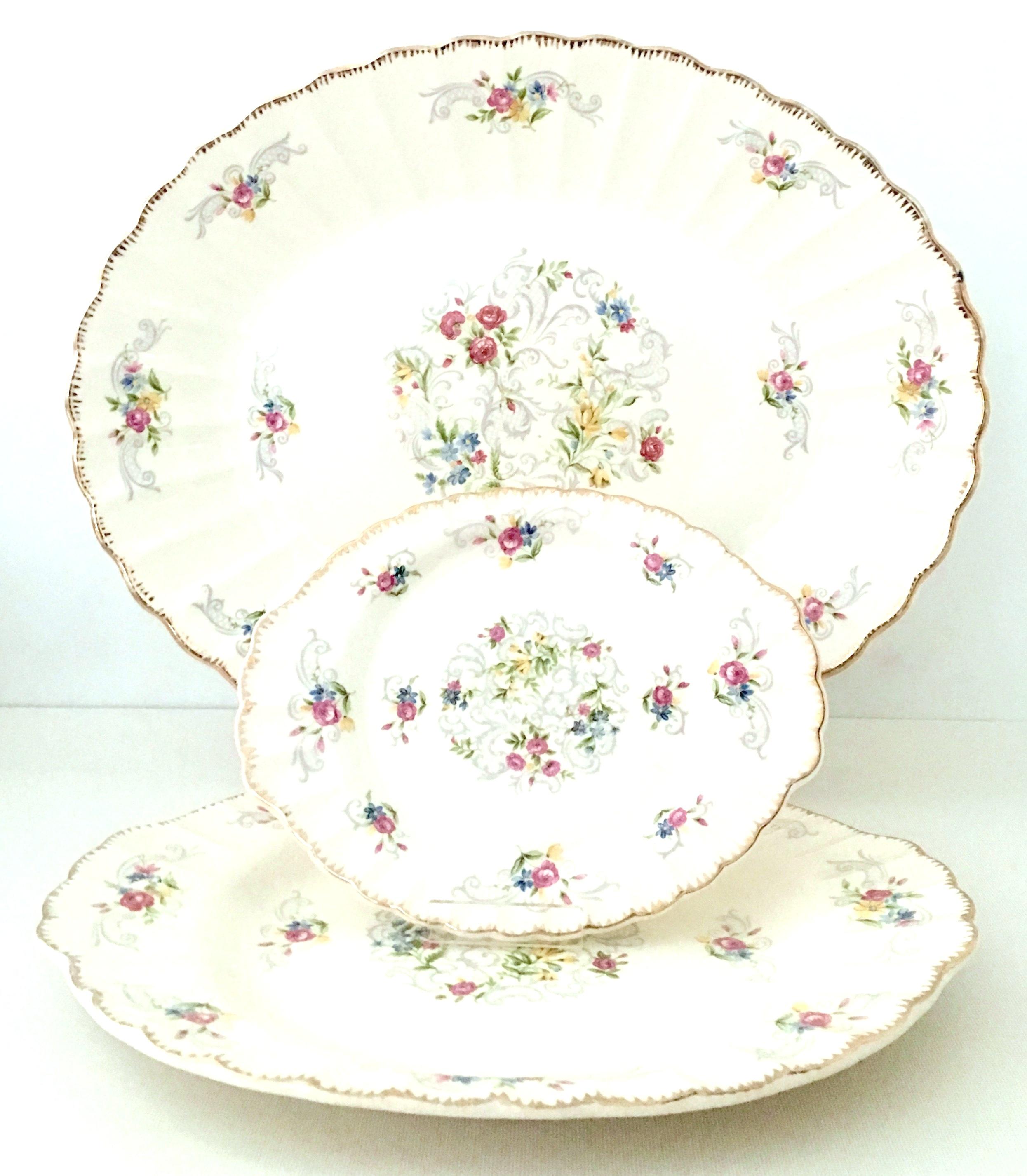 Midcentury American Limoges set of 19 pieces by, Jennie Lind. Pattern features an off-white ground with hand painted filigree 22-karat gold edge and a vibrant with muted gray scroll floral pattern. Each piece is signed on the underside, Made In The