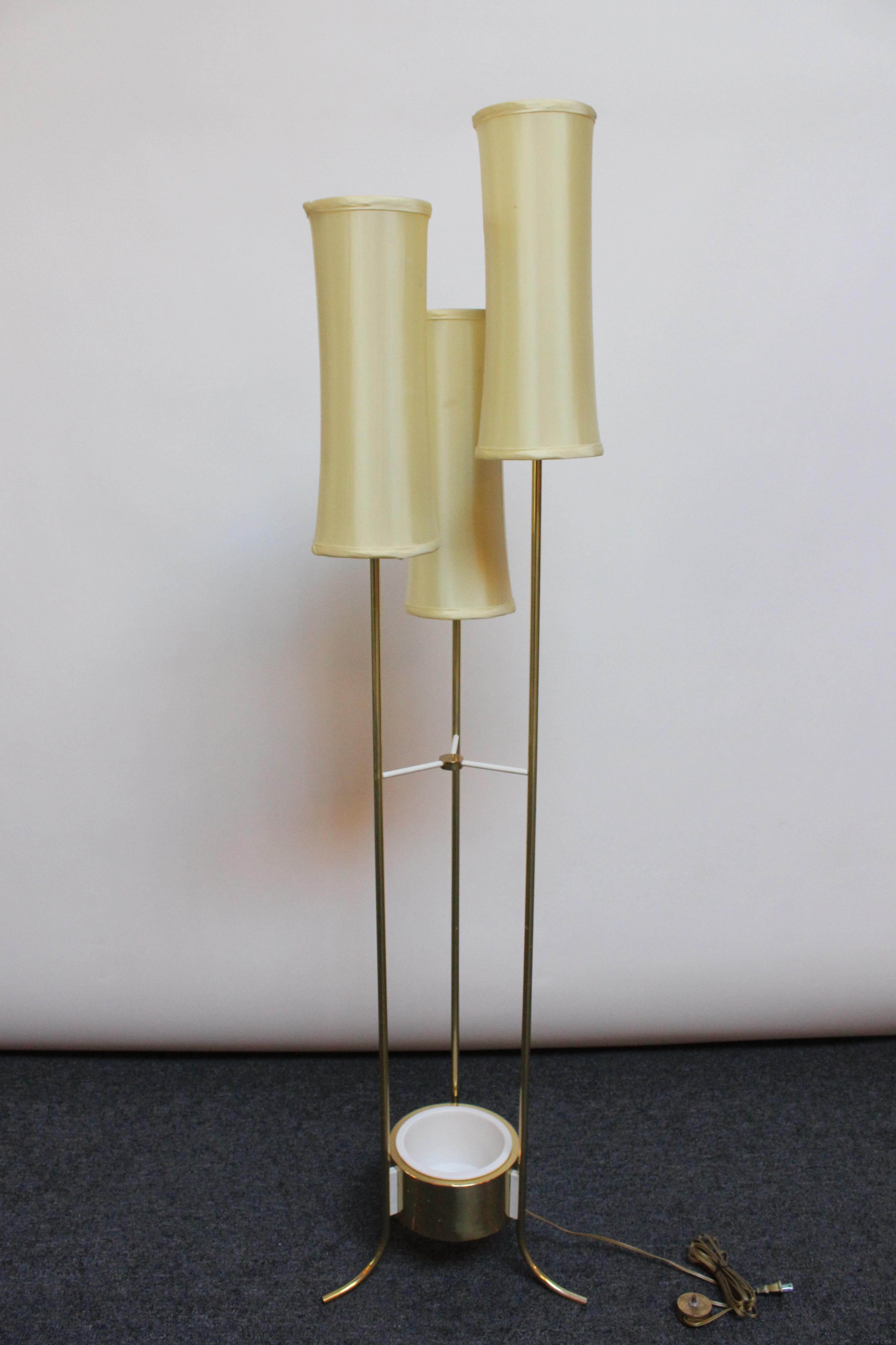 Three-fixture brass floor lamp with painted metal accents and a white ceramic insert planter. Vintage linen shades are included, though not original to the piece. 
Includes original brass on / off foot pedal. 
Brass shows light wear, as pictured,