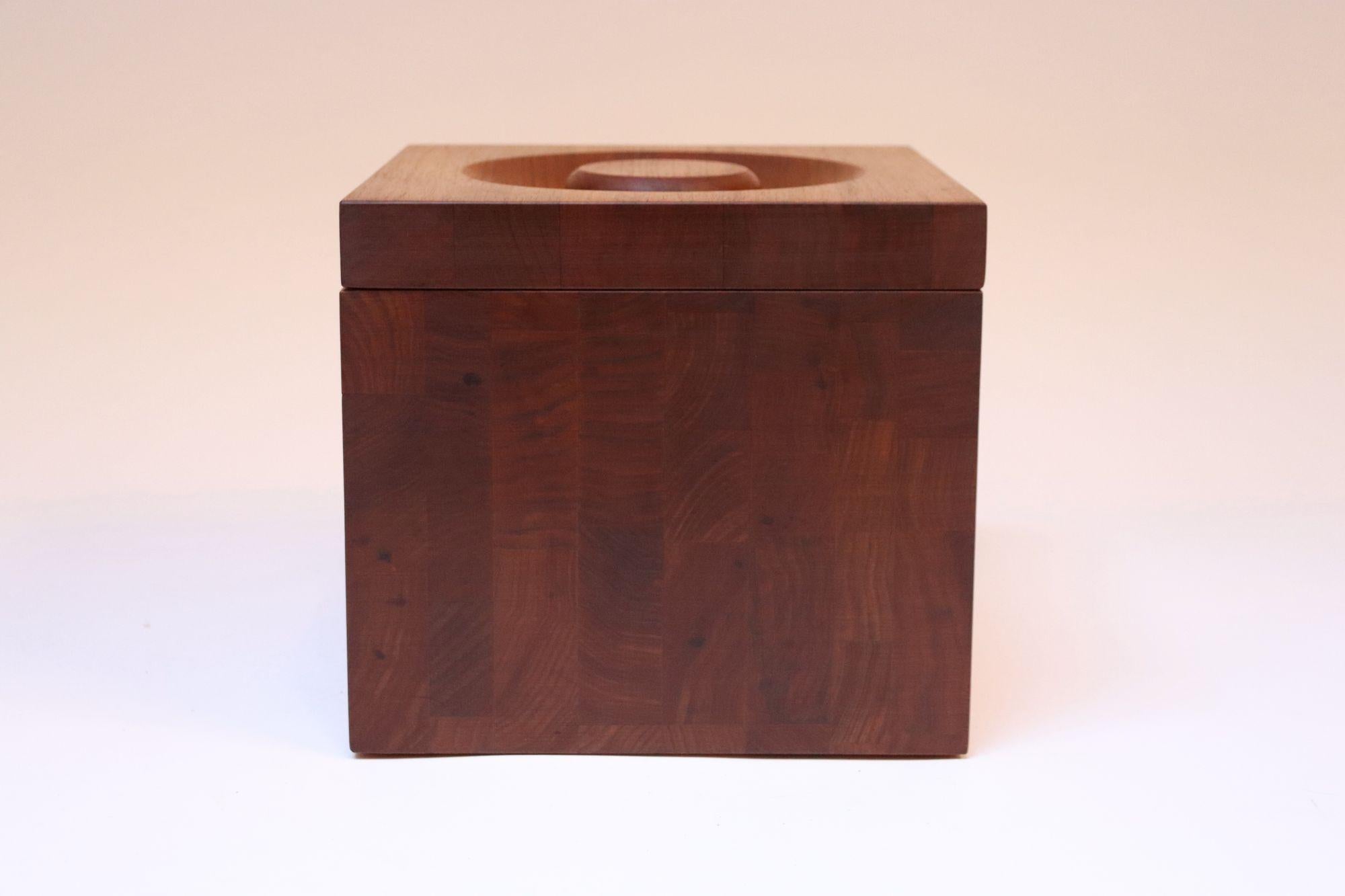 Portaghiaccio a cubetti realizzato da JK Adams di Dorsett, Vermont, negli anni Sessanta.
Attraente pezzo in legno massiccio di noce con rivestimento in plastica color crema accentuato da quattro fori sulla parte anteriore e posteriore che esaltano