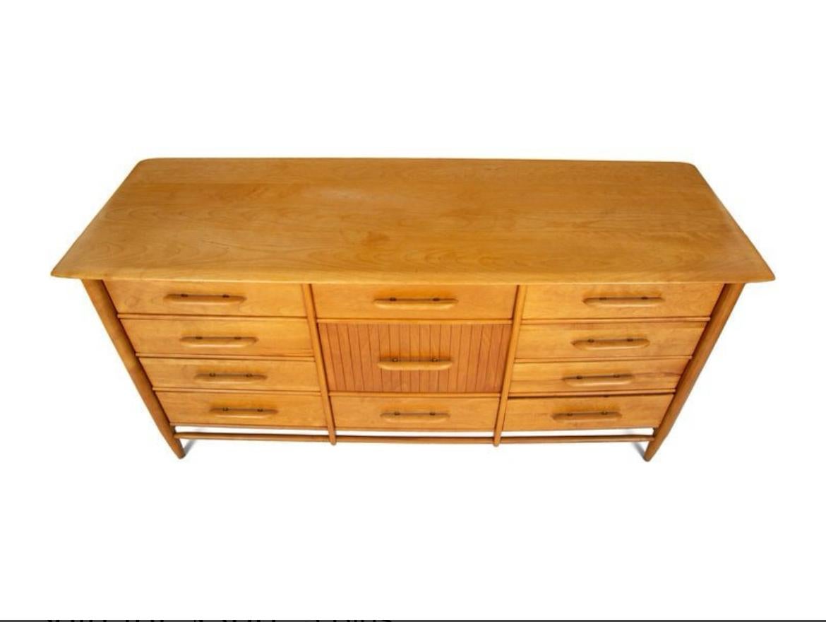 Mid century modern blonde solid maple low 11 drawer dresser. Has curved details with tapered dowel upright legs. Carved maple handles with brass details. Solid maple drawers with dovetail joints. Nicely built mid century American modern American