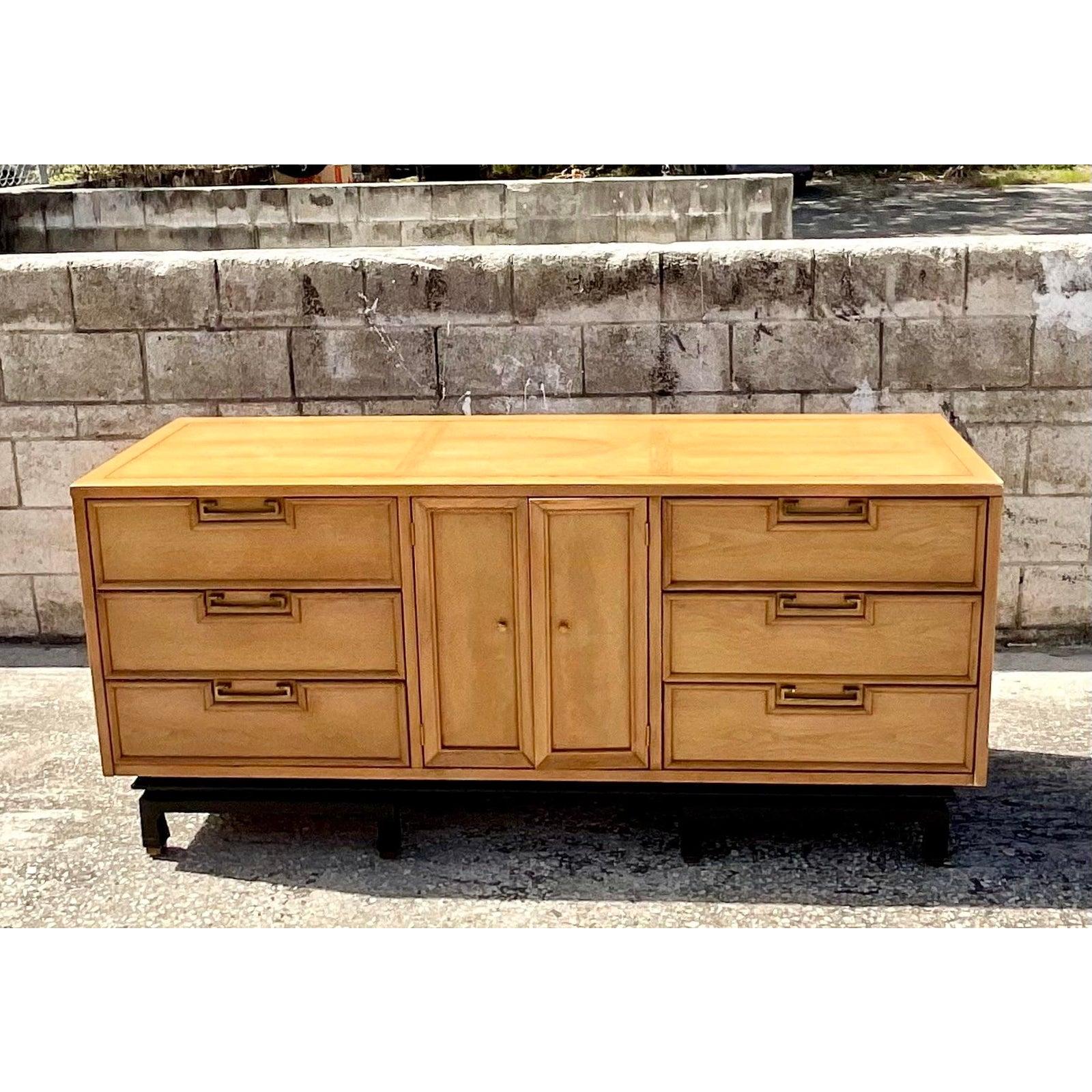 A fantastic vintage midcentury dresser. Made by the iconic American of Martinsville group. A chic bleached mahogany cabinet with brass hardware and raised apron plinth. Acquired from a Miami estate.