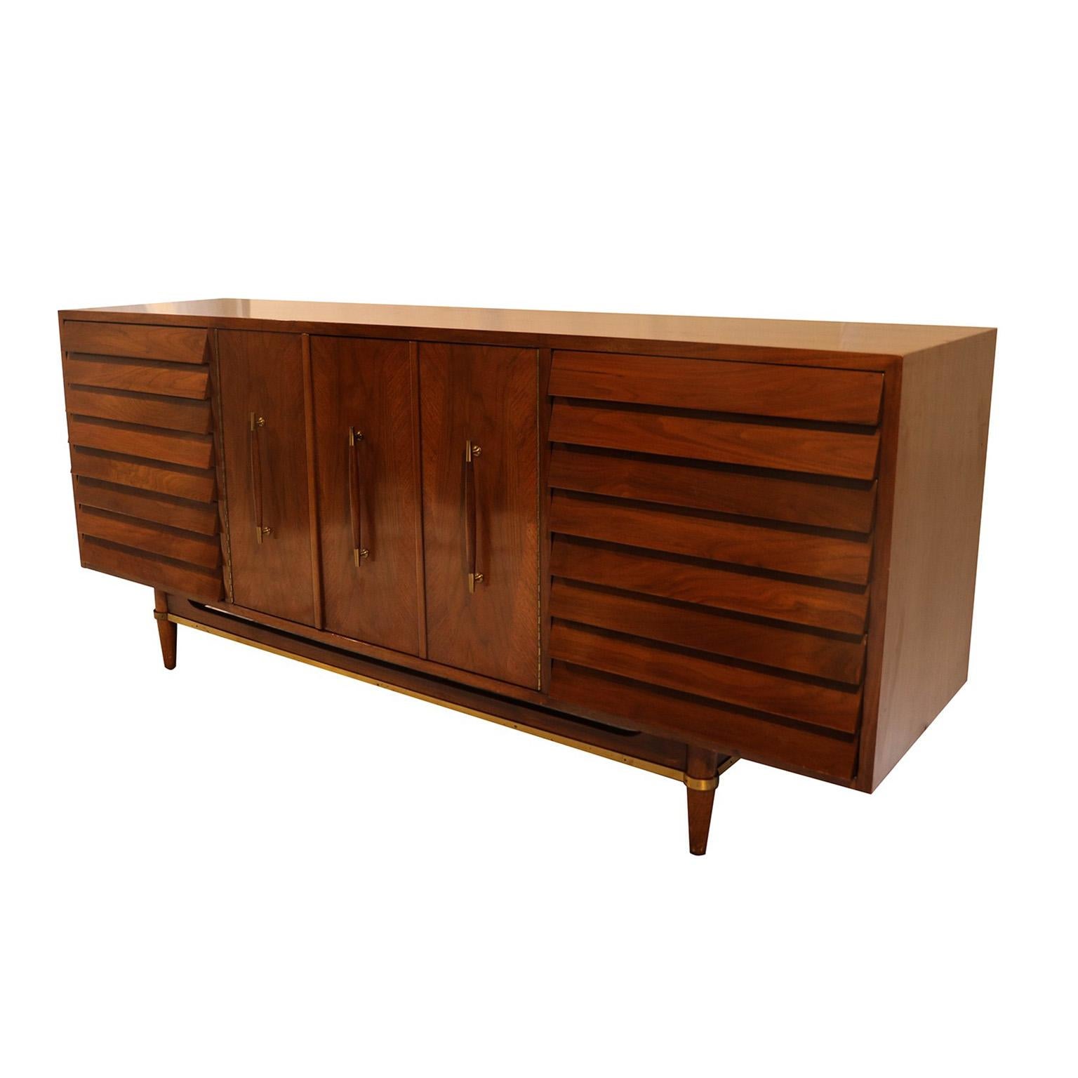 Beautifully detailed and proportioned walnut American of Martinsville credenza sideboard, one of the most esteemed furniture producers of the midcentury era, in great original condition. Designed by Merton Gershun for the “Dania” line. With its