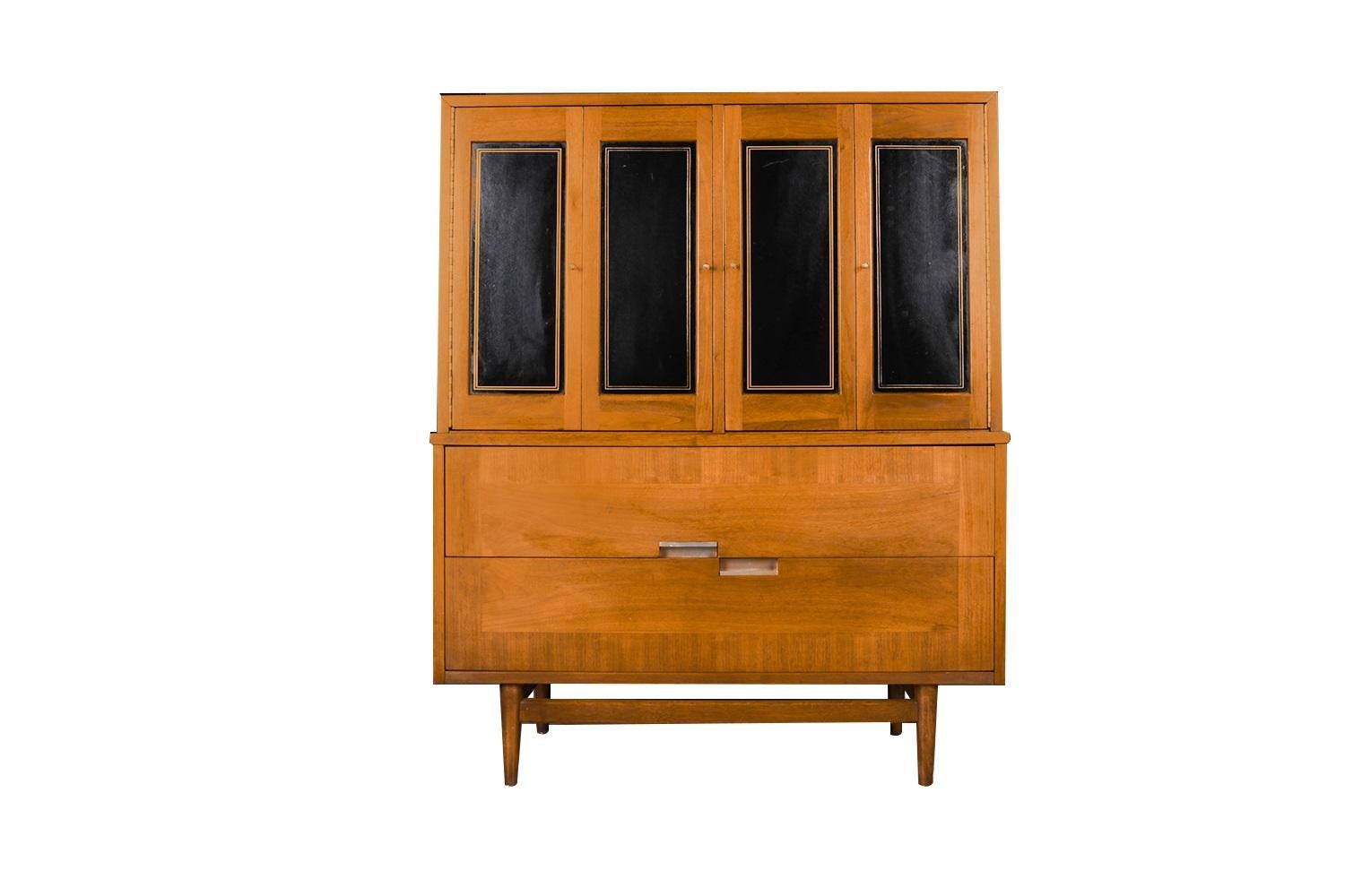 This exceedingly well-crafted American of Martinsville highboy dresser was designed by Merton Gershun for American of Martinsville, features the mid-century style and construction quality that keep these pieces in such high demand today. Beautiful