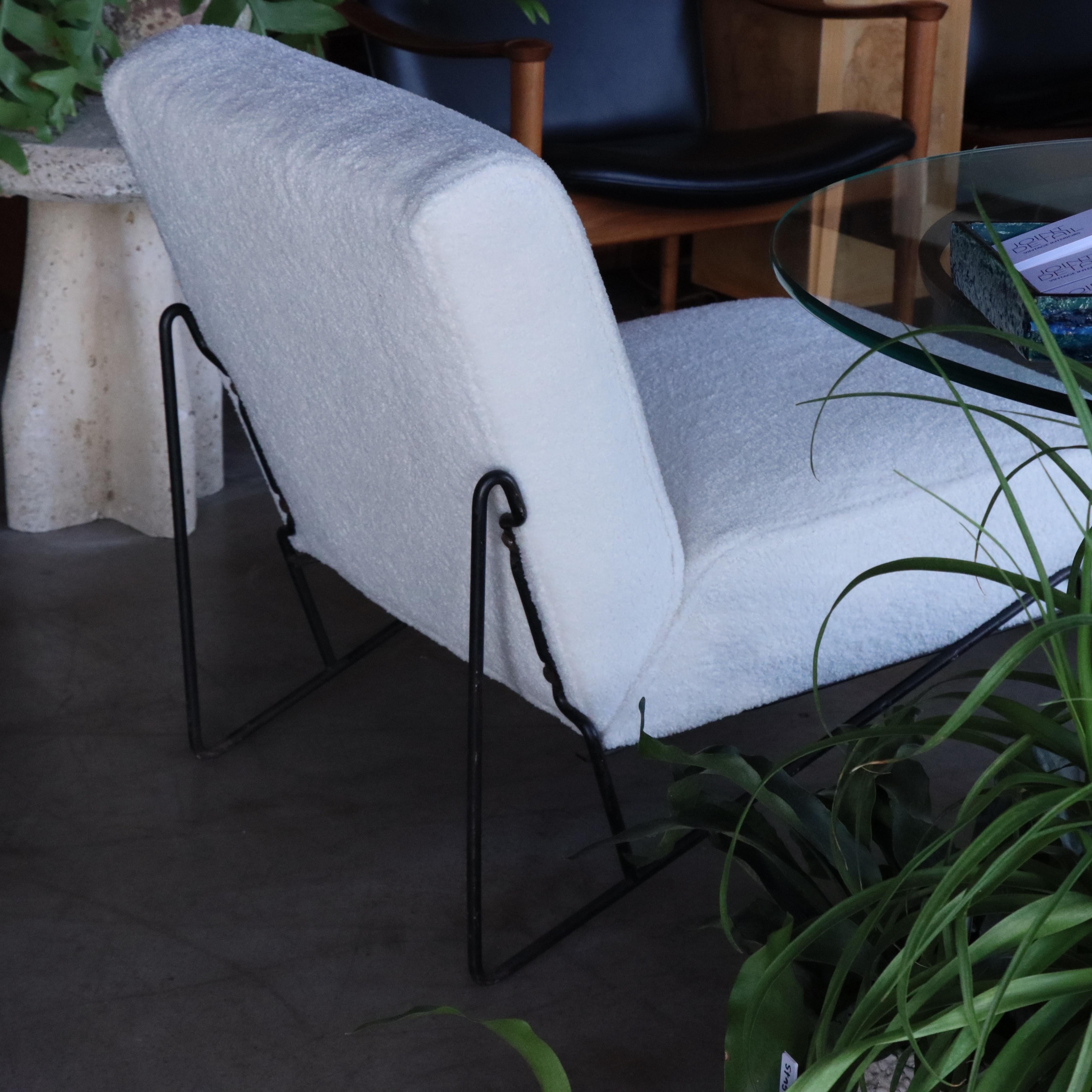 Silla zapatilla de mediados de siglo, pintada y con estructura de hierro, recientemente tapizada en imitación de piel de oveja. El marco presenta signos leves de envejecimiento y desgaste, como arañazos y algunas pérdidas de pintura que hemos dejado