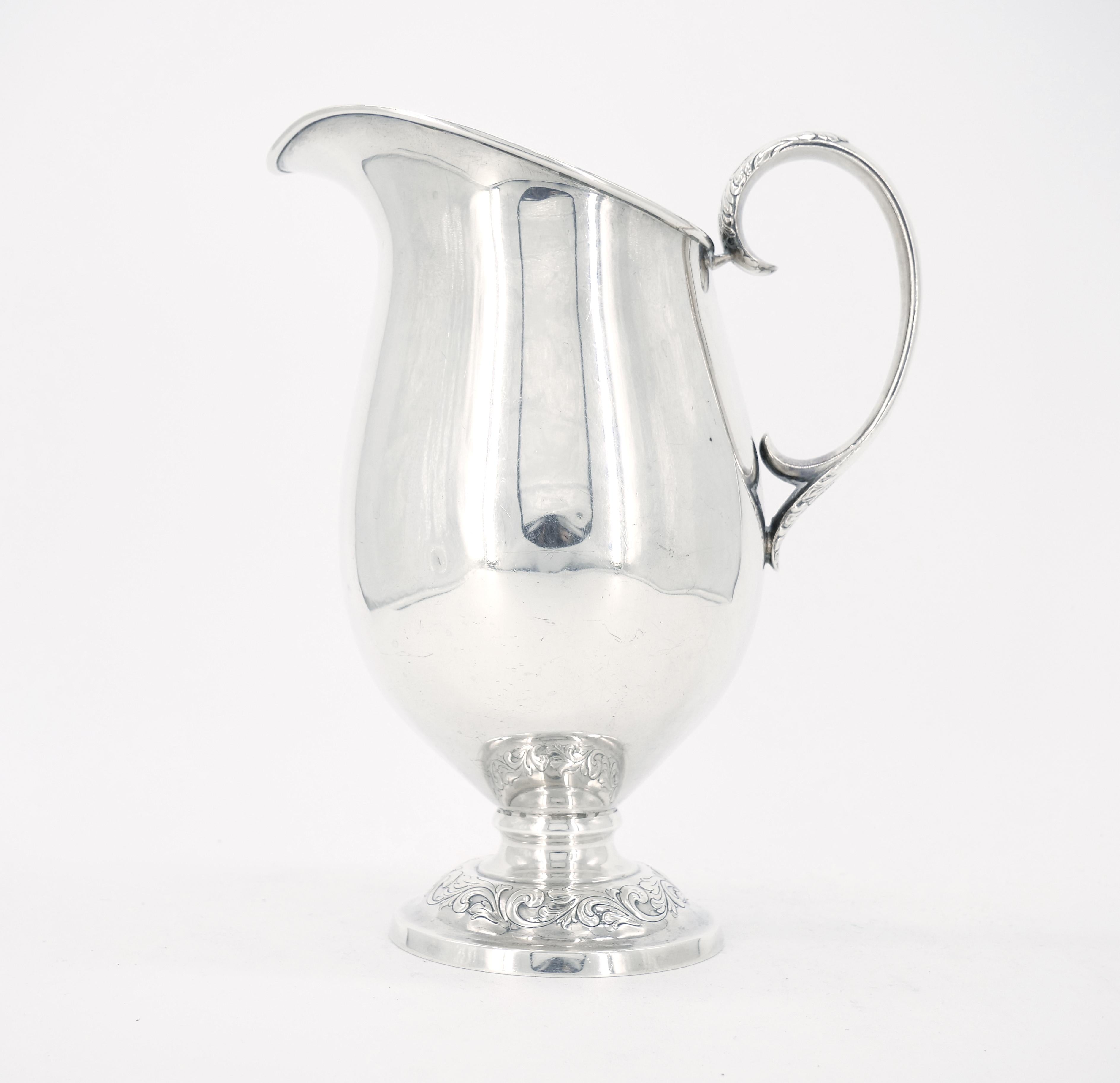 Lovely sterling silver barware water pitcher or jug from Towle with repousse and chased scrolling foliate motif on the foot and c-shaped handle with engraved acanthus motif.