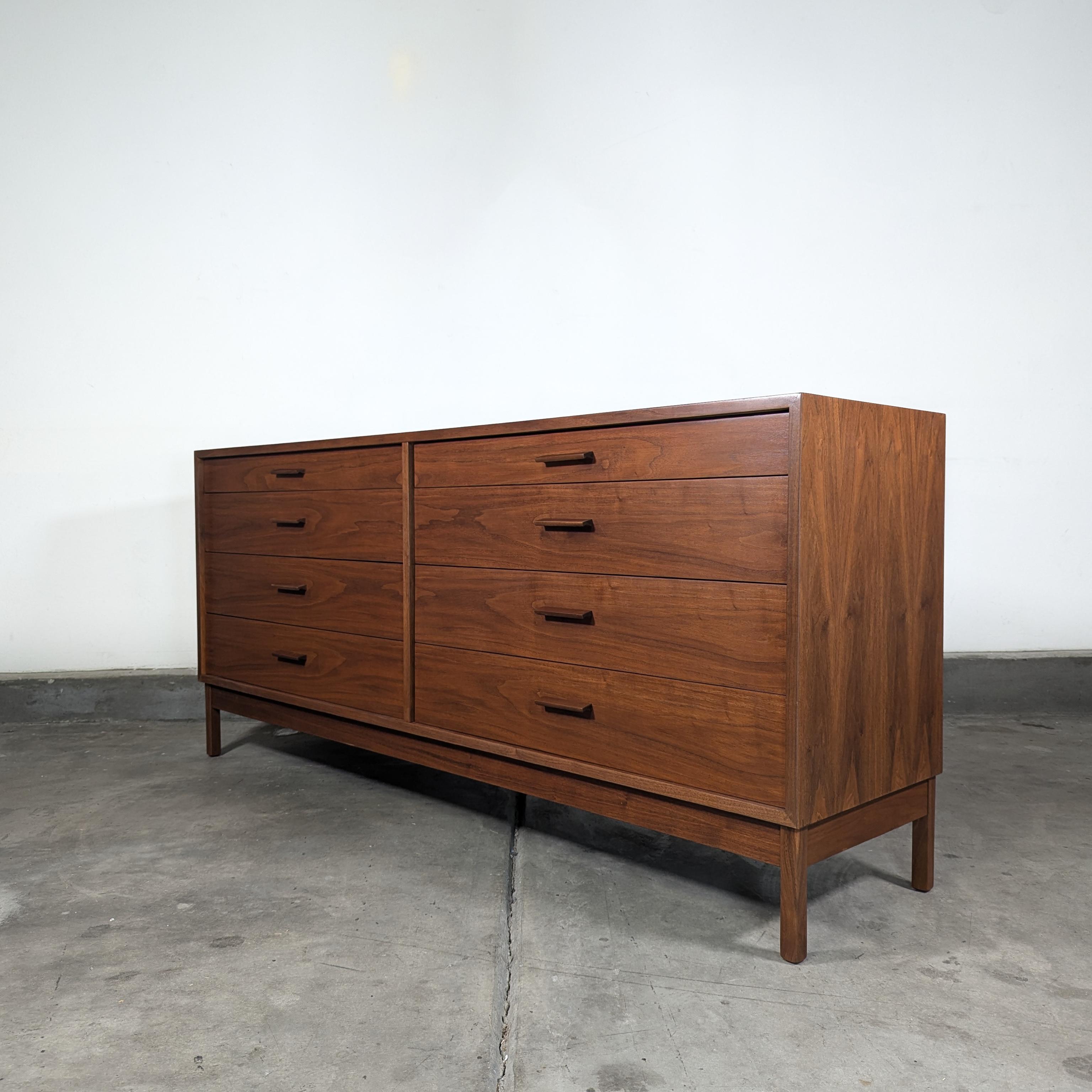 Step into mid-century elegance with this exquisite vintage American Studio Craft walnut 8-drawer dresser by the renowned Richard Artschwager, circa 1960s. Measuring approximately 71.5 inches wide, 17.5 inches deep, and 31.5 inches high, this