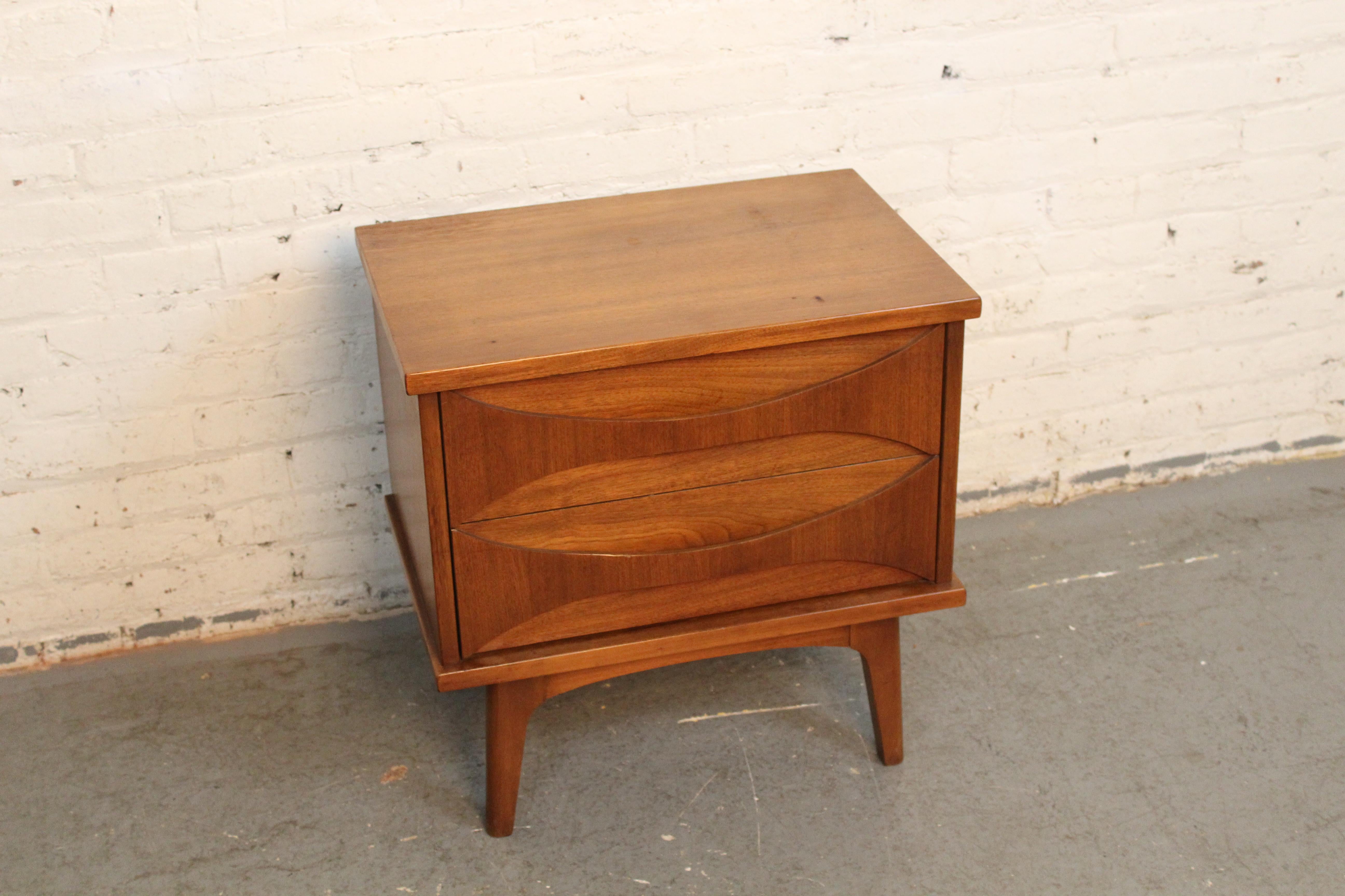 Add a touch of class to your bedside with this vintage bowtie-styled nightstand! Designed and built by United Furniture Corporation of Ronda, North Carolina it features timeless American construction paired with a charming vintage modern style. The