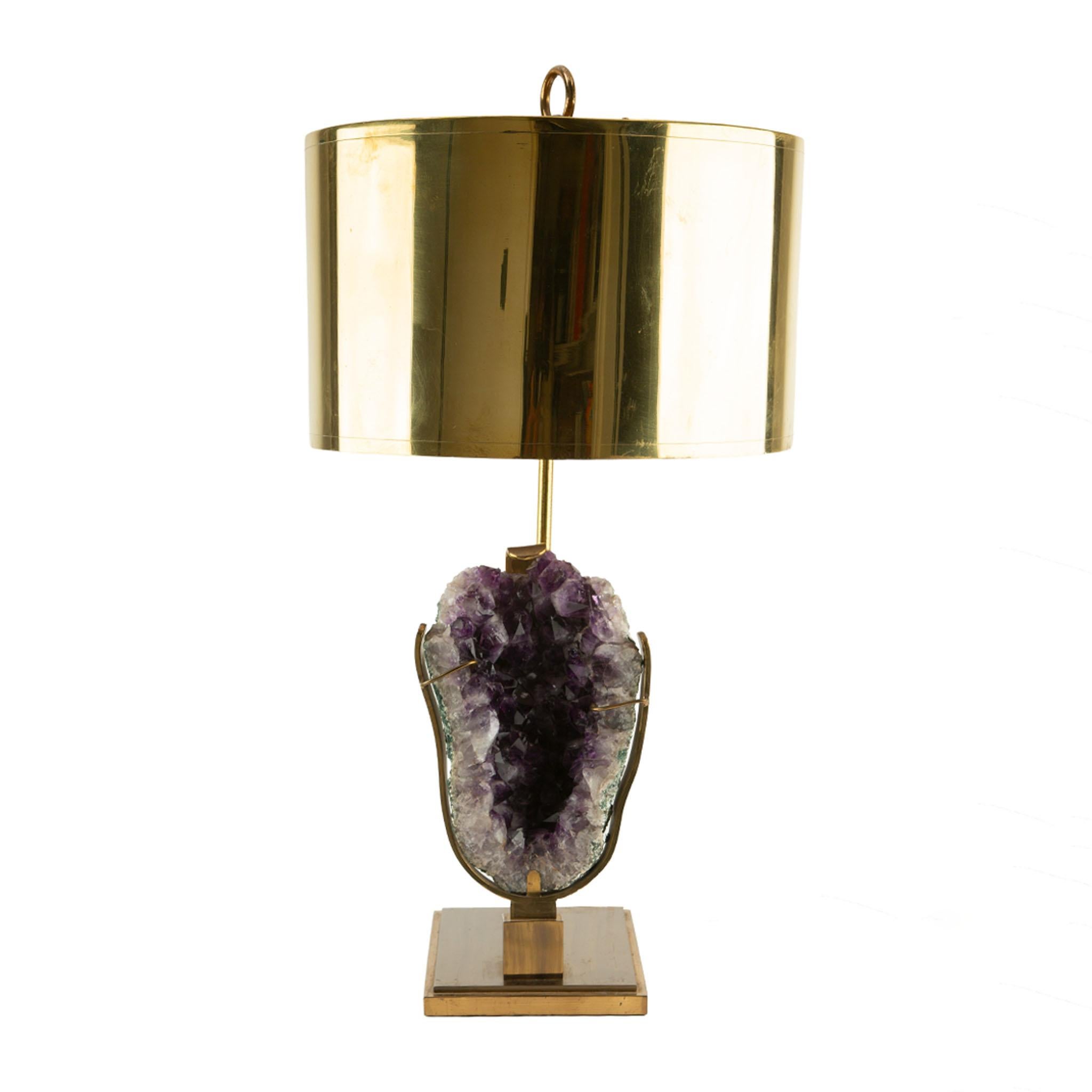Lampada da tavolo di metà secolo con un sorprendente esemplare di cristallo naturale di ametista come base, abbinato a un paralume in ottone caldo che completa le ricche sfumature viola del minerale. L'ametista, con le sue sfaccettature grezze,