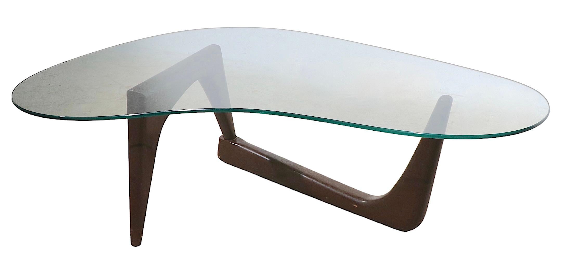 Classic mid century free form glass top coffee table with sculptural wood base and amoeba form glass top. The base is constructed of solid wood, and is flexible at the connection joint, it is in later, but not new, brown paint finish. The thick