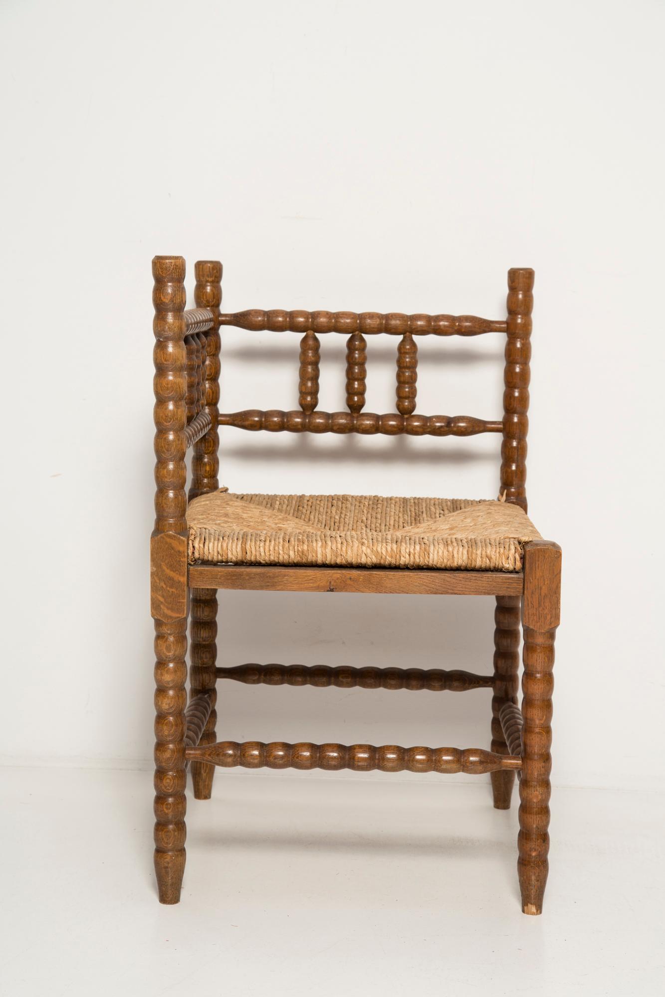 A fine French Provincial corner chair in stained oak with a handmade cane seat. Classic bobbin turned legs and in a overall fine vintage condition. Made in the 19th century.  Lovely handmade chair that will complement many interior styles. A modern,