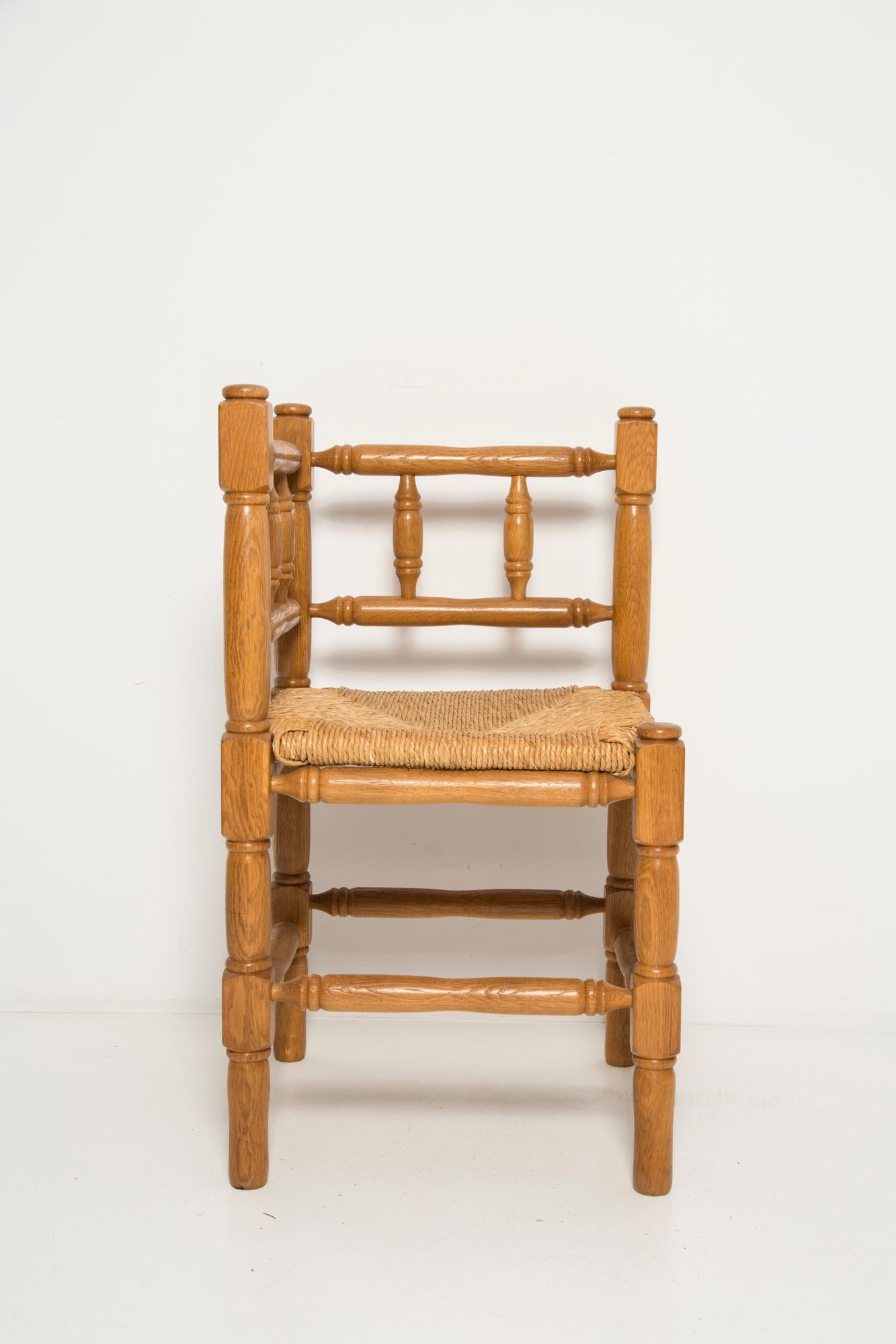 A fine French Provincial corner chair in stained oak with a handmade cane seat. Classic bobbin turned legs and in a overall fine vintage condition. Made in the 19th century.  Lovely handmade chair that will complement many interior styles. A modern,