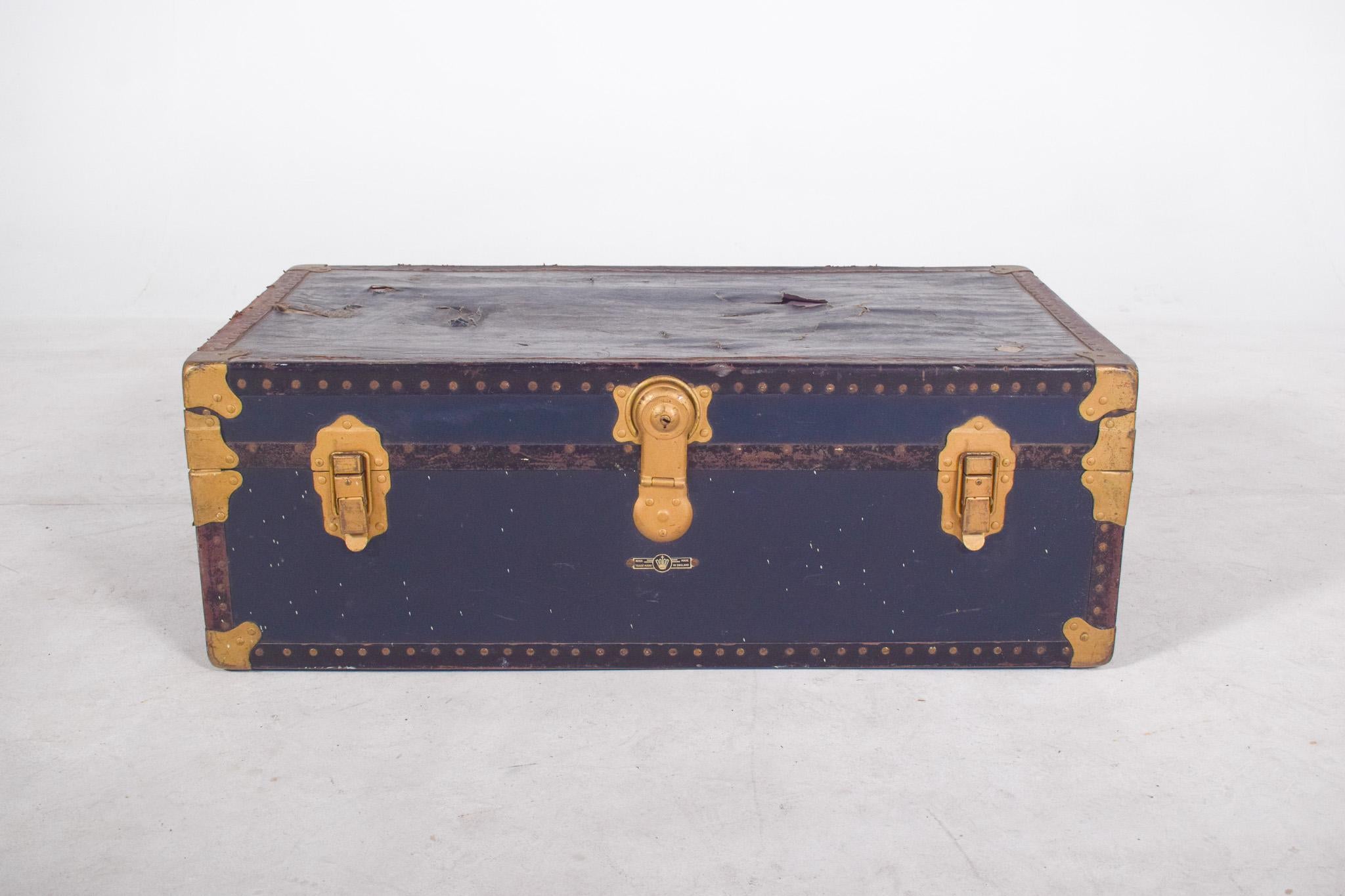 Antica borsa da viaggio rivestita in pelle blu. Con finiture in ottone placcato oro su bordi, angoli e cerniere. La struttura è rinforzata con borchie su tutto il perimetro, che le conferiscono robustezza e carattere decorativo. Ha una maniglia