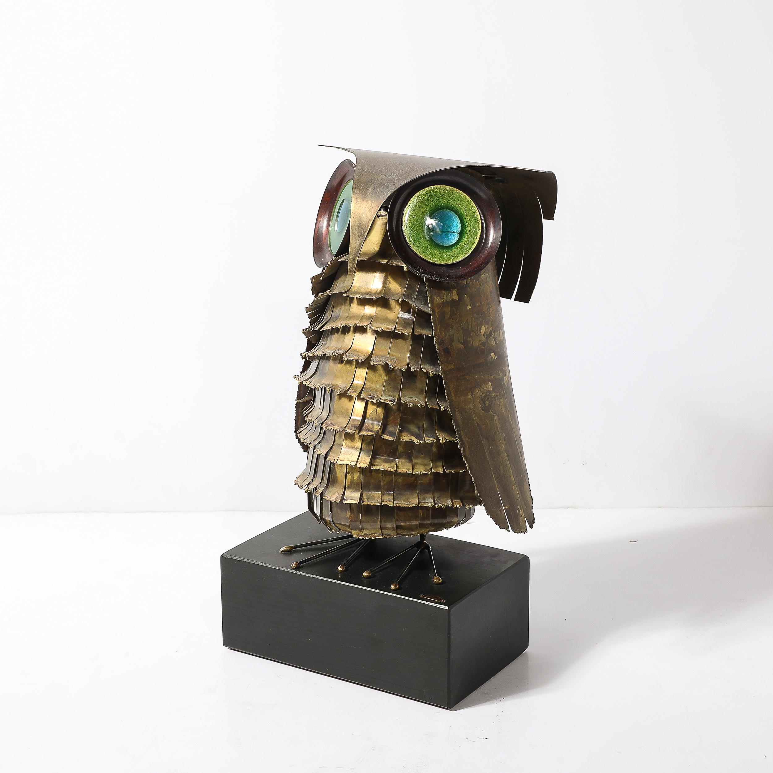 This captivating Mid-Century Modernist owl sculpture, signed by the renowned design firm Curtis Jere, is a striking example of artistic innovation from the era. Crafted in America around 1968, the sculpture features antiqued brass and glass,