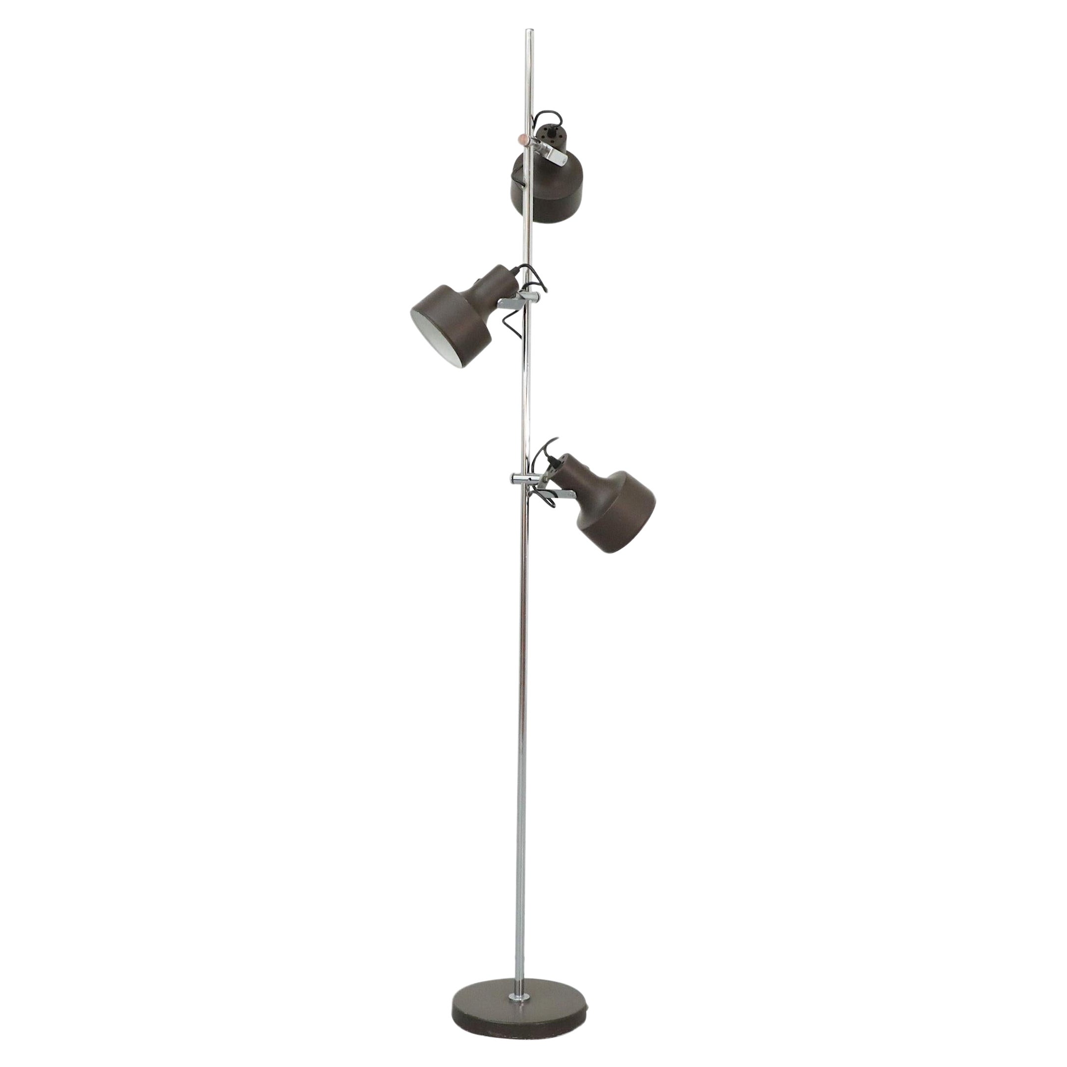 This Mid-Century, Anvia made floor lamp has three adjustable spots that allow you to customize the amount of light you need for any given task. The handsome, dark brown enameled metal spots can be moved up and down the base and easily adjusted in