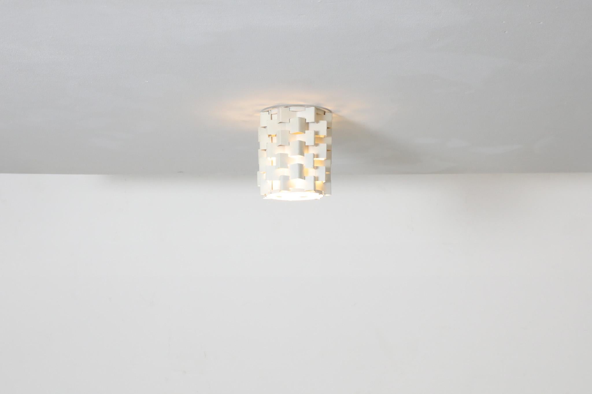 Mid-Century architecturally structured, Anvia style, geometric enameled metal flush mount ceiling lights in white. Attributed to Lightcraft, USA, 1950s-1960s. In original condition, with visible wear, chips and enamel loss. Wear is consistent with