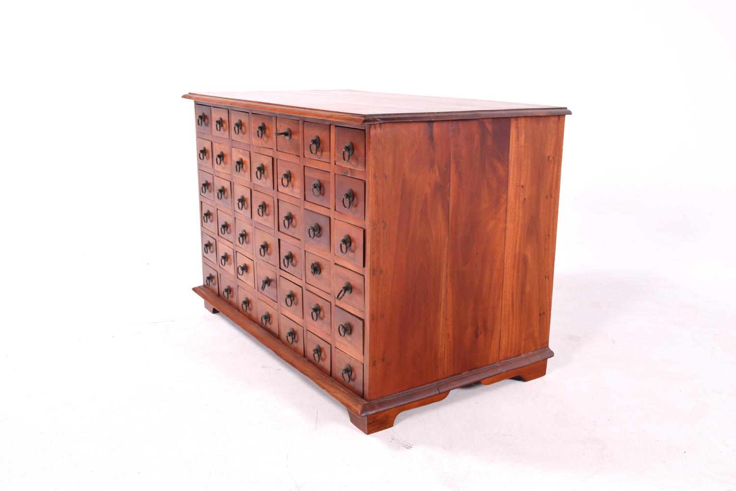 A stunning 42 drawers apothecary cabinet, in mahogany. The chest features a nice subtle Asian design in mahogany wood. Original metallic hardware.