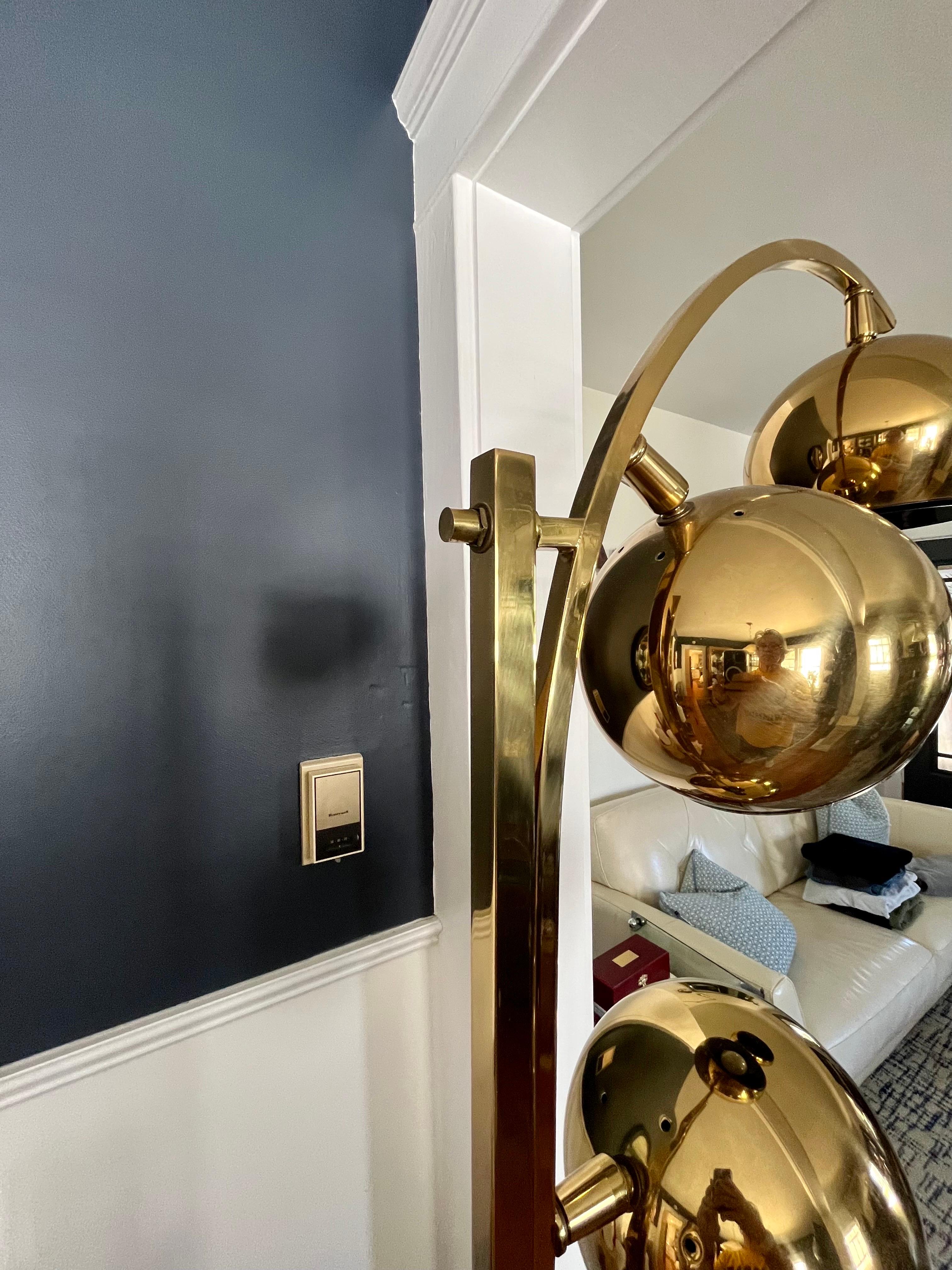 Stunning monumental arc 3 eyeball floor lamp, circa 1970s, designed in the manner of Italian designer Castiglioni. Features three brass spherical directional shades . Handsome architectural form. Lighting may be selected for one or too brightness