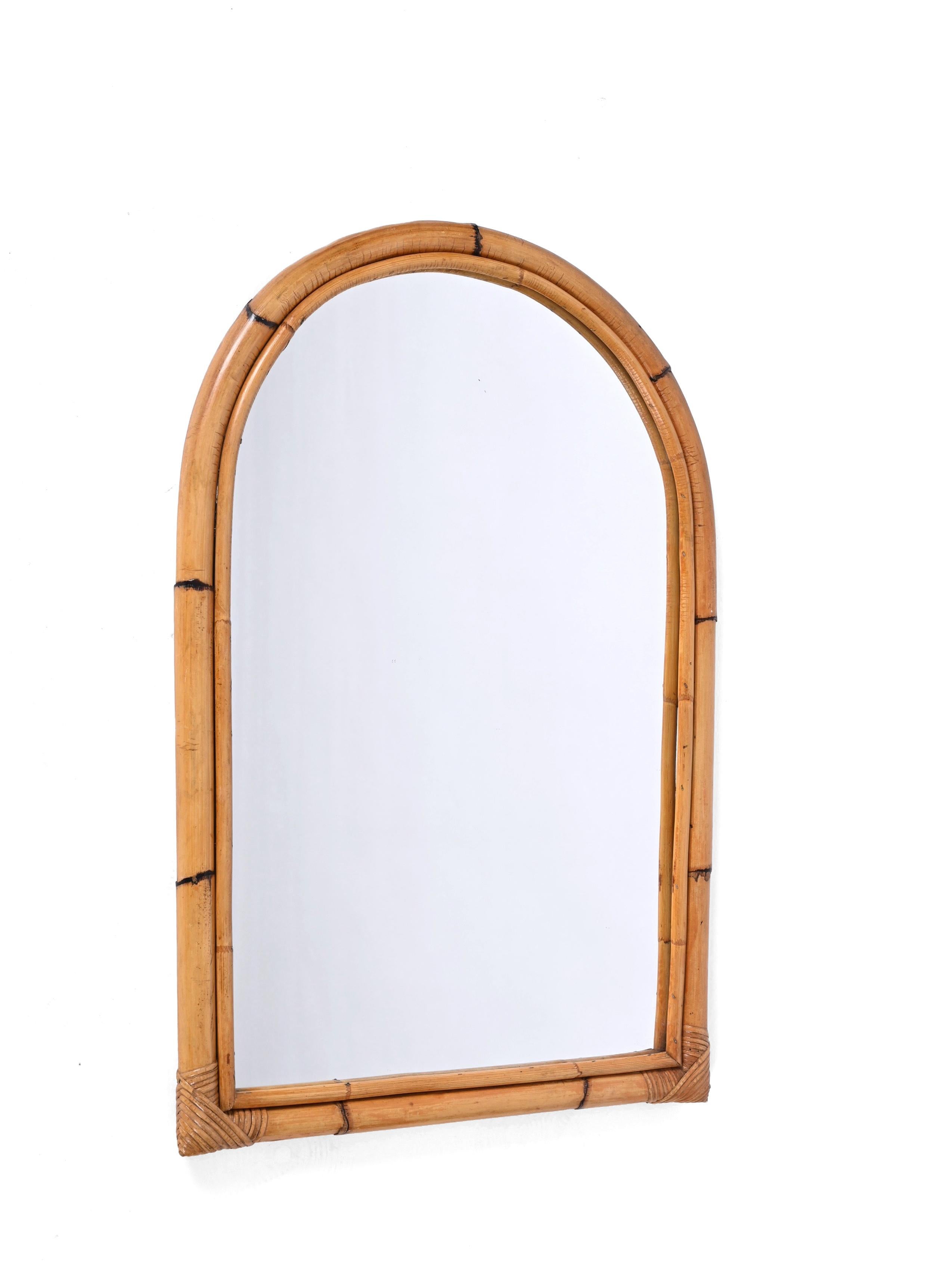 Gorgeous midcentury arched mirror with double bamboo cane frame. This fantastic item was produced in Italy in the 1970s.

The way the two-round bamboo canes curve together creating a perfect arch and integrate the glass mirror is superb and