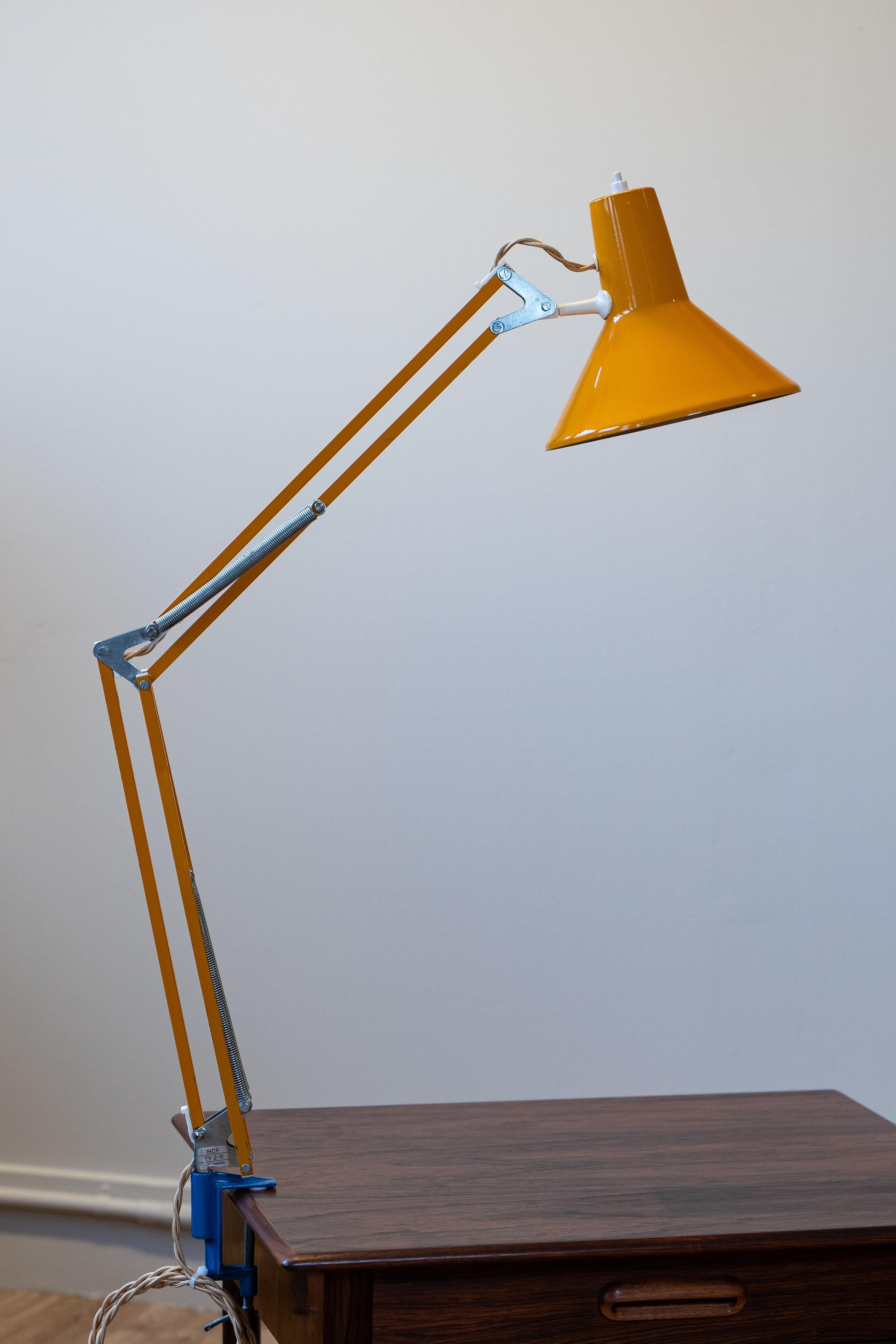 This yellow architect lamp, crafted by HCF Denmark, is a perfect blend of functional design and vibrant style. Dating back to the mid-20th century, this piece captures the essence of Danish modernism with its clean lines, adjustable arm, and bold