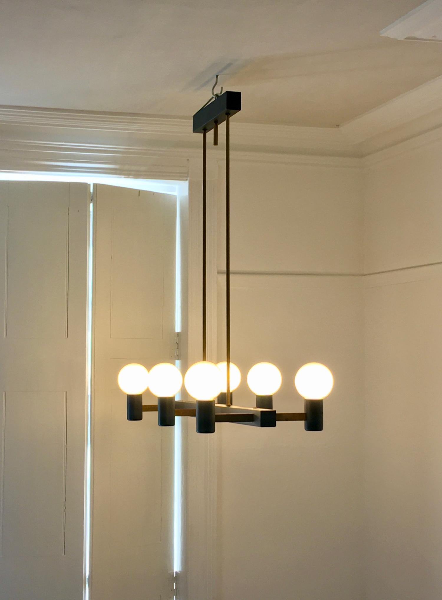 Steel and brass chandelier with minimal architectural lines. Mid-20th century, Netherlands. A simple piece of modern design, nicely made, consisting of six lamp-holders in a grey steel frame with brass cross-bars; the style and overall silhouette