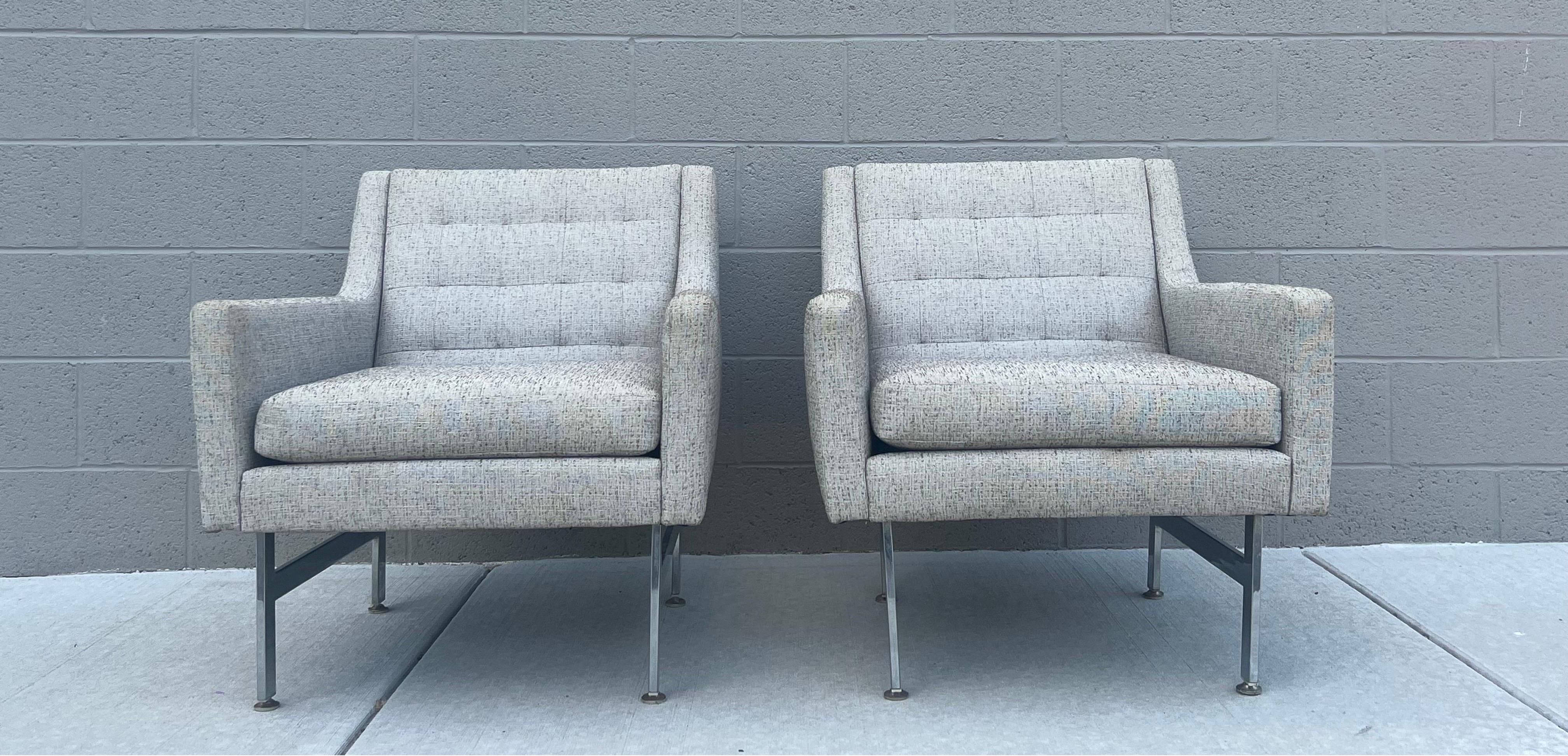 Mid-Century Modern pair of arm chairs. Boxy design with sleek side profile. Sits on chrome bar legs that are shorter towards the back to create a sloping angle and maximum comfort. These chairs have been reupholstered from the original fabric.