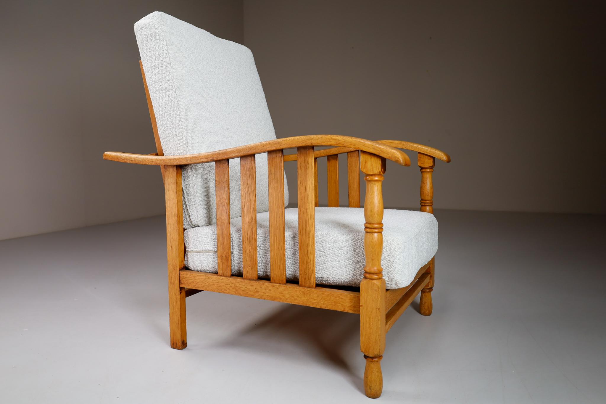 Fauteuil ou chaise longue du milieu du siècle fabriqué et conçu en France dans les années 1950. Fabriqué en bois de chêne et retapissé professionnellement en tissu bouclé. Ces fauteuils constitueraient un ajout attrayant à tout intérieur tel que le