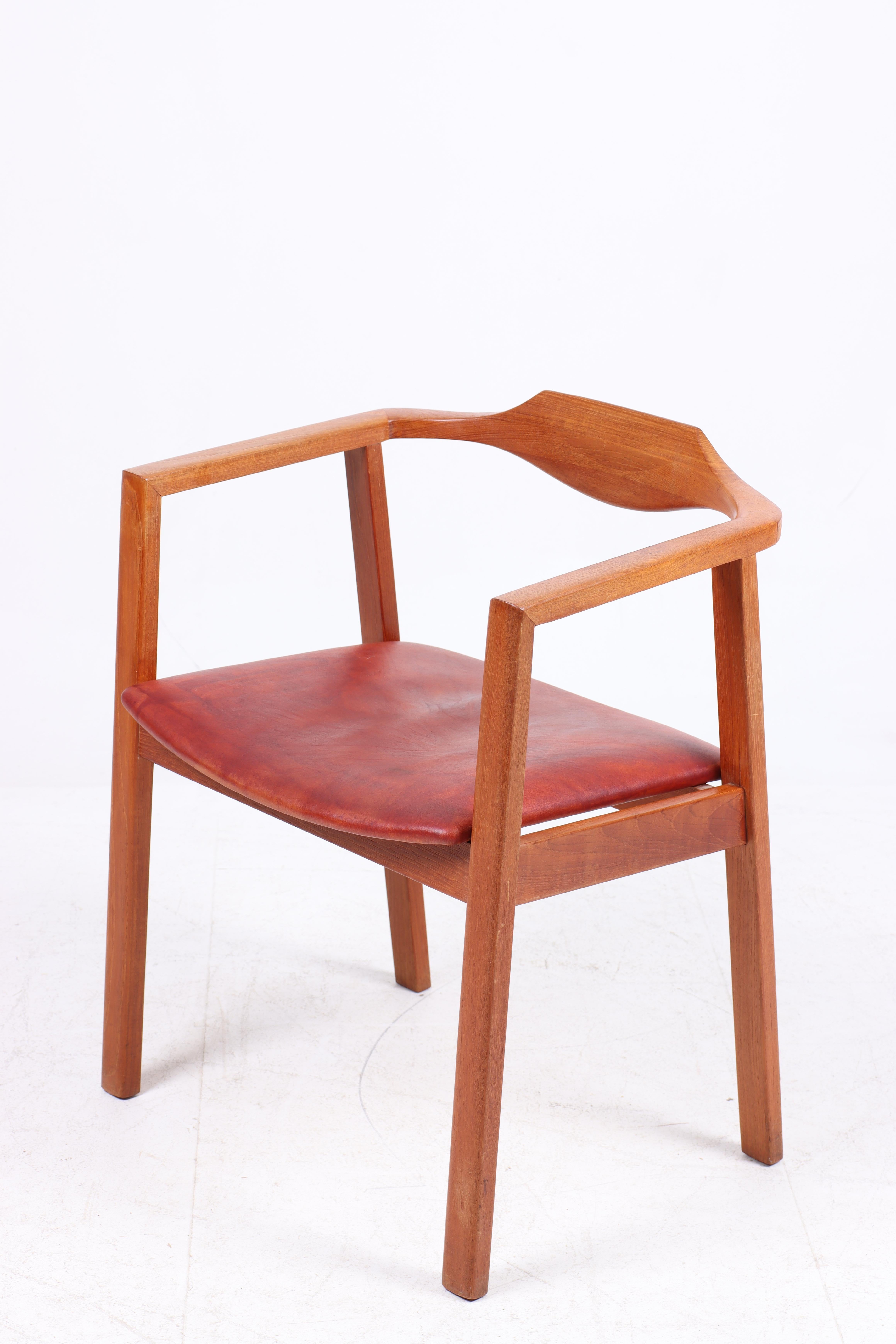 Danish armchair in patinated leather and solid teak frame. Designedand made in Denmark. Great original condition.