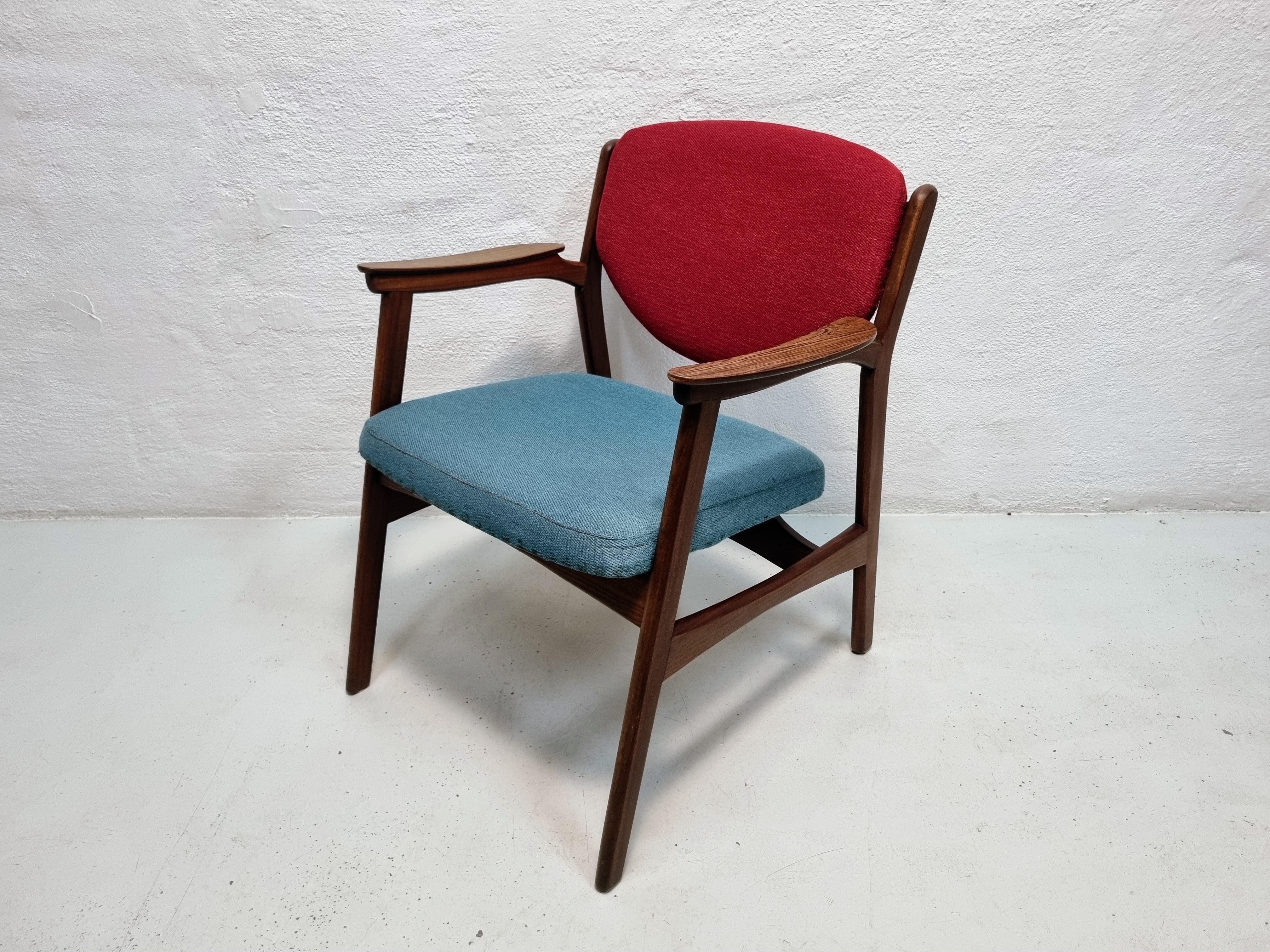 Rare armchair with solid teak frame and rosewood armrests, upholstered in blue and red upholstery fabric.
The chair is attributed to the Norwegian designers Rolf Rastad and Adolf Relling.