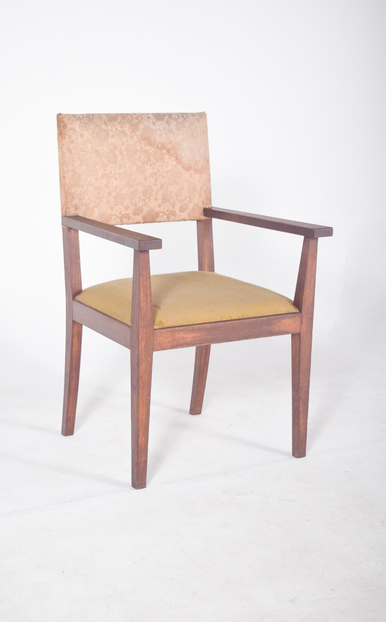 Sillón con asiento y respaldo tapizados. Con el típico diseño modernista de mediados de siglo, tiene líneas rectas, una estructura funcional y ninguna ornamentación. El marco de madera tiene un acabado sencillo, con patas ligeramente inclinadas. Los