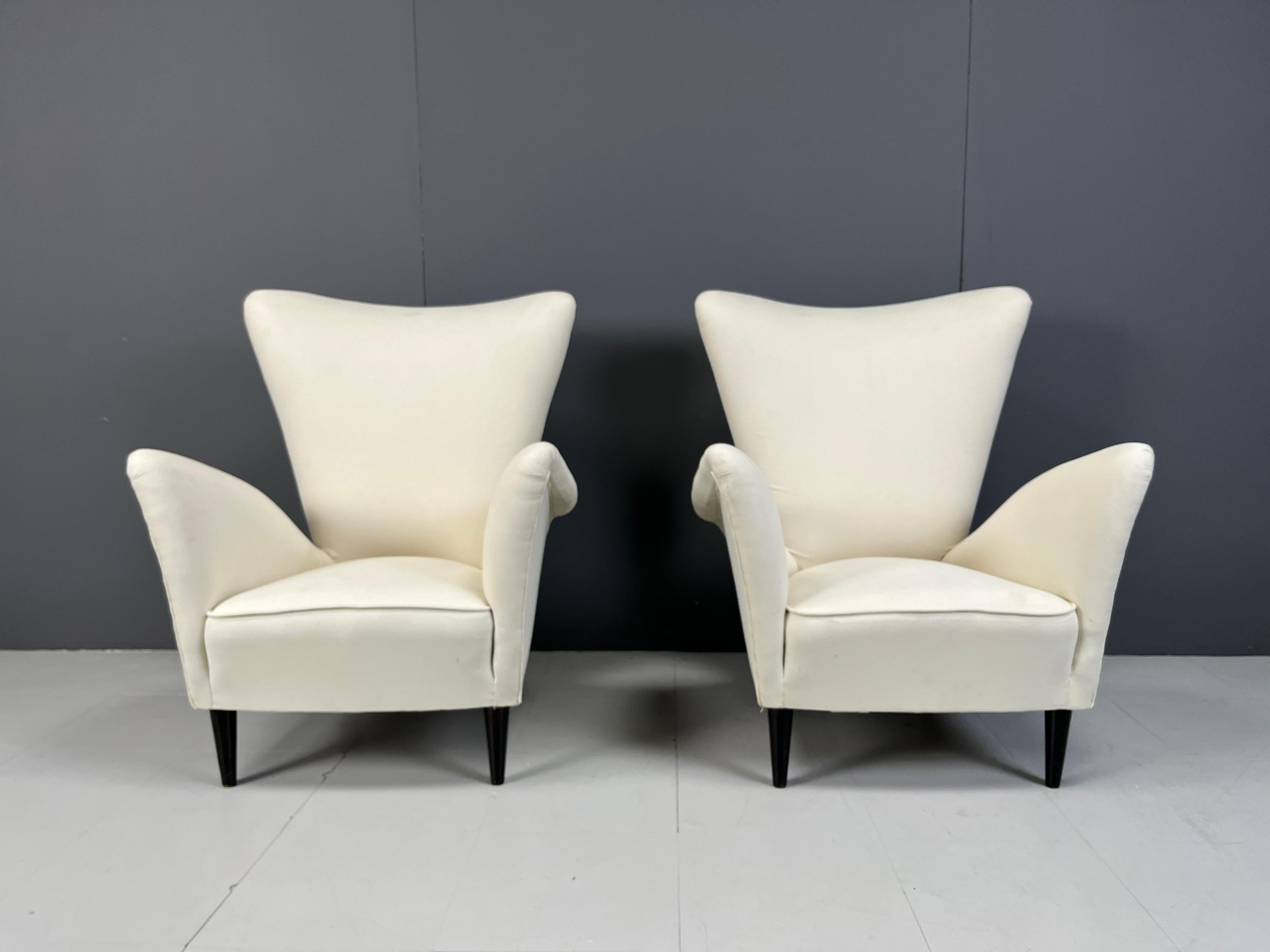 Fauteuils italiens du milieu du siècle, conçus par Gio Ponti dans les années 1950.

De belles formes incurvées avec un revêtement en tissu blanc et des pieds incurvés en bois ébonisé.

Un magnifique design italien intemporel qui s'intègre
