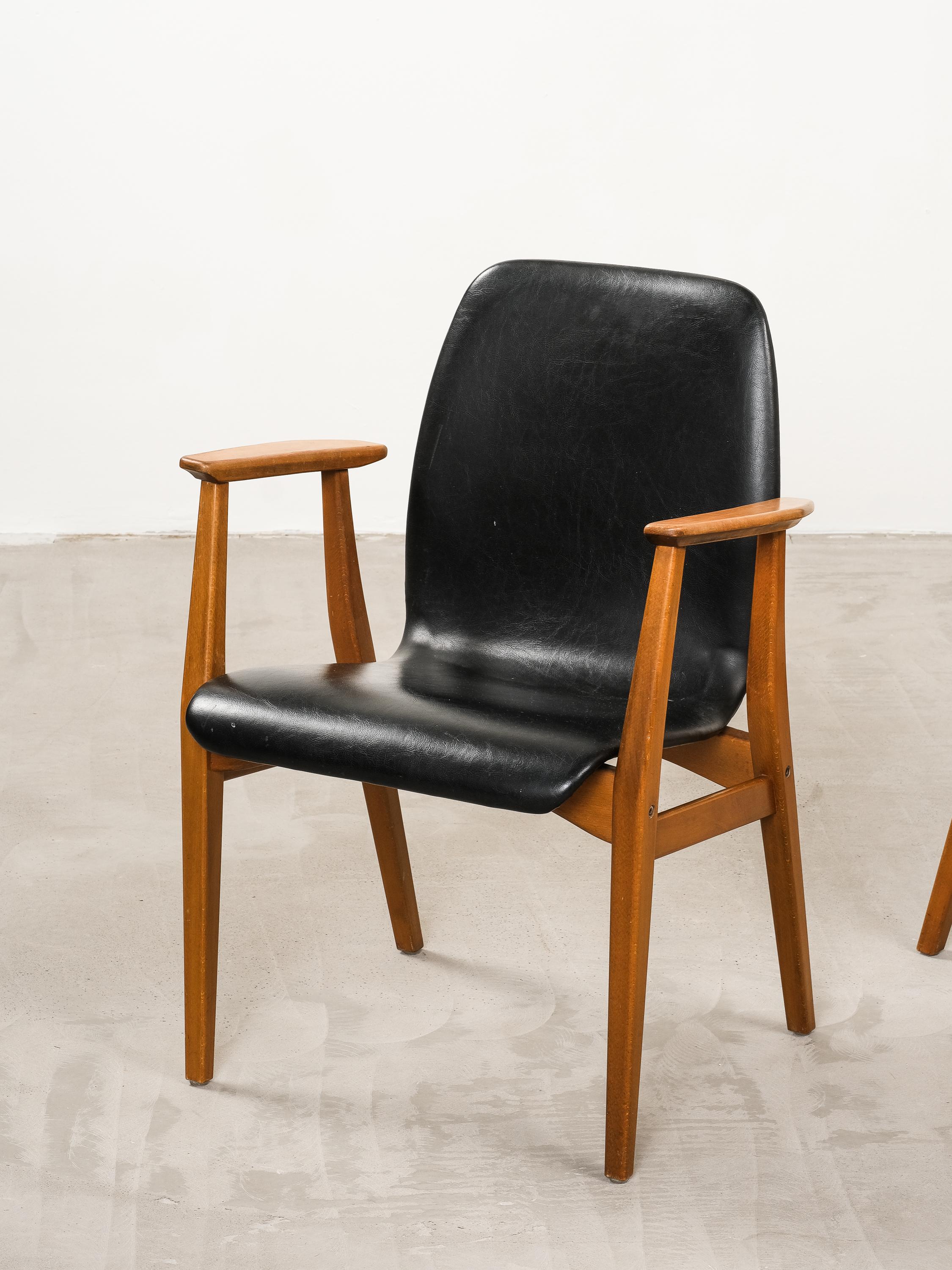 Ces fauteuils ont été fabriqués dans les années 1960 par l'entreprise suédoise Svegards Markaryd. Le châssis des chaises est en bois de hêtre massif, l'assise et le dossier des chaises sont recouverts du revêtement d'origine en similicuir noir.