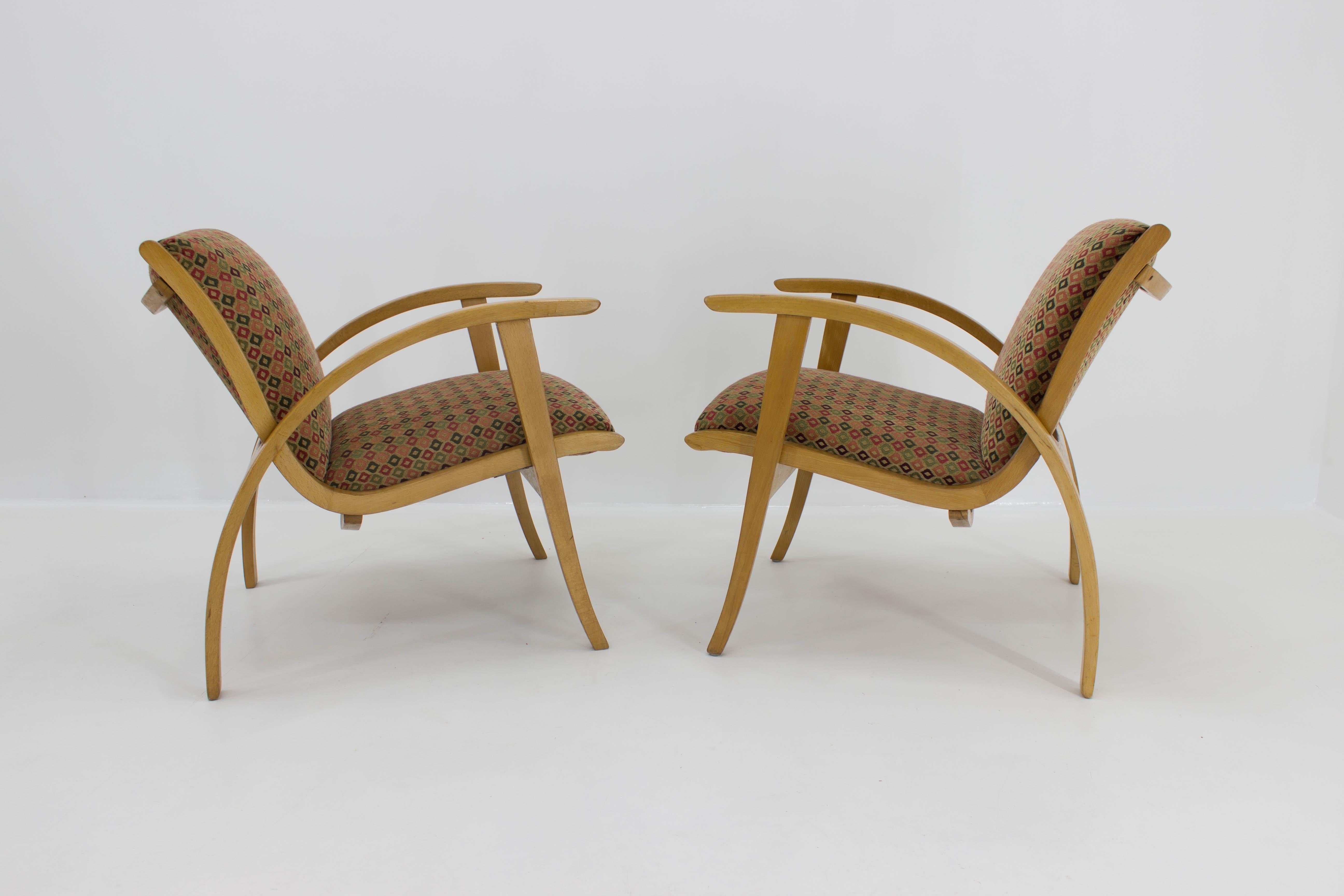 Pair of charming and comfortable midcentury armchairs, reupholstered, 1960s.
One armchair has fixed legs on a bottom side by metal strip: very sturdy and stabile